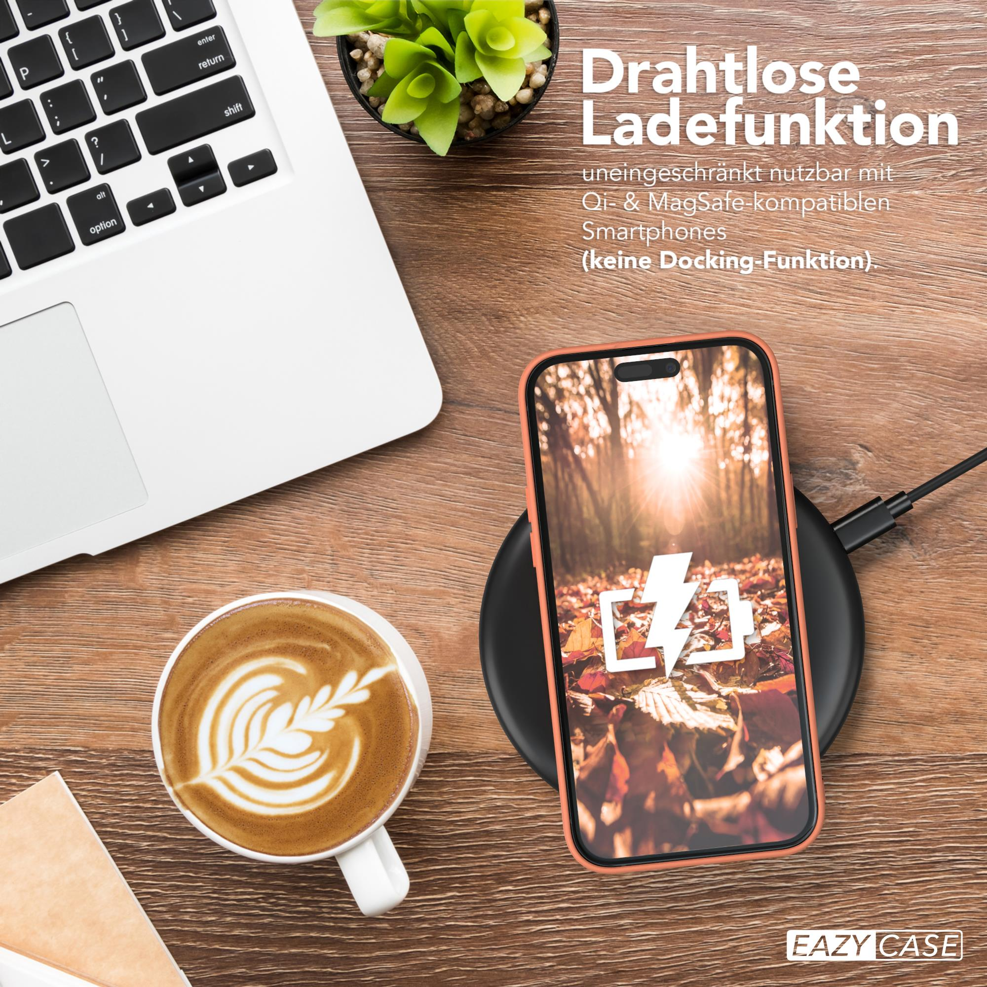 Ein Telefon, das drahtlos auf einem Pad neben einem Laptop und einer Tasse Kaffee geladen wird.