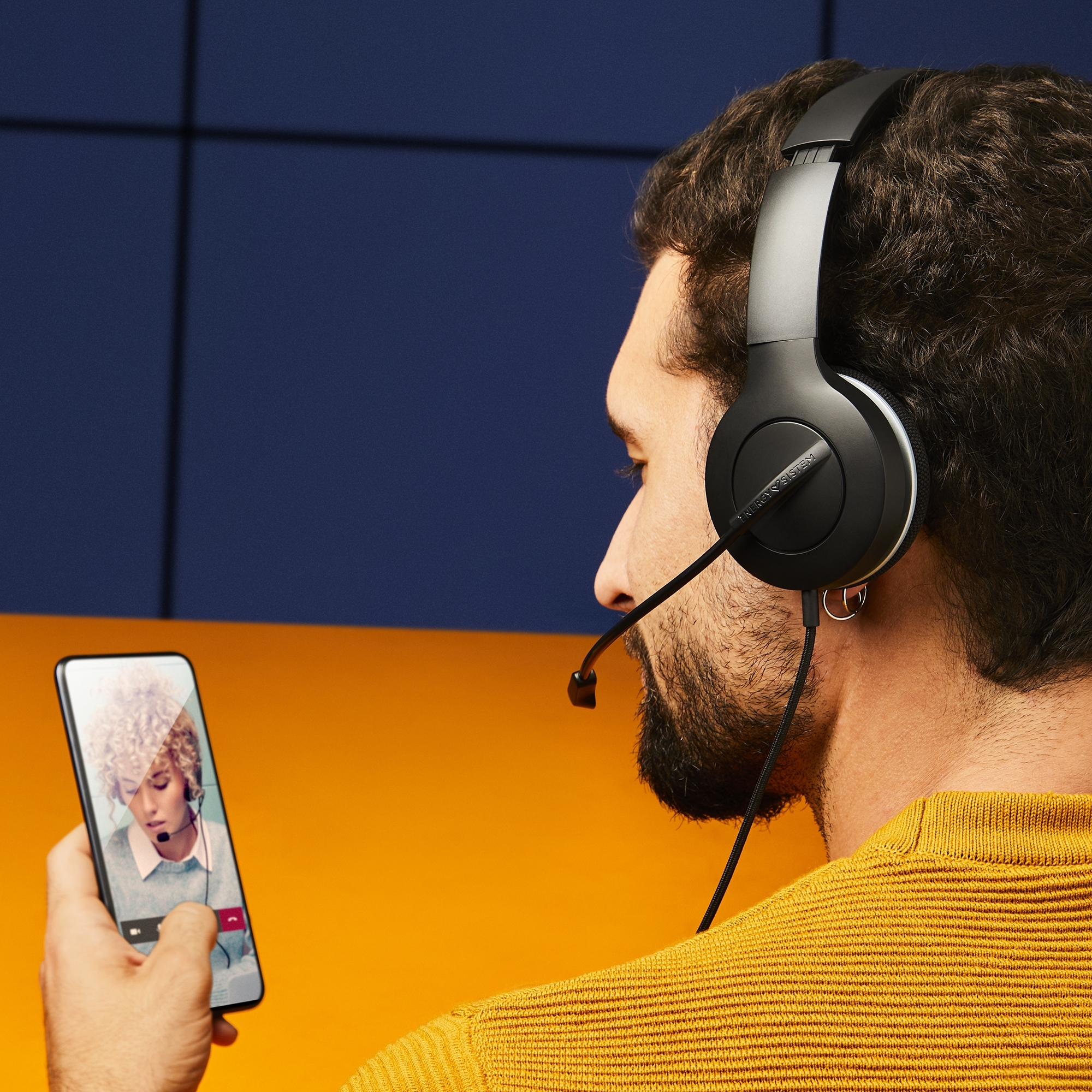 Un hombre con auriculares está en una videollamada en un teléfono inteligente.