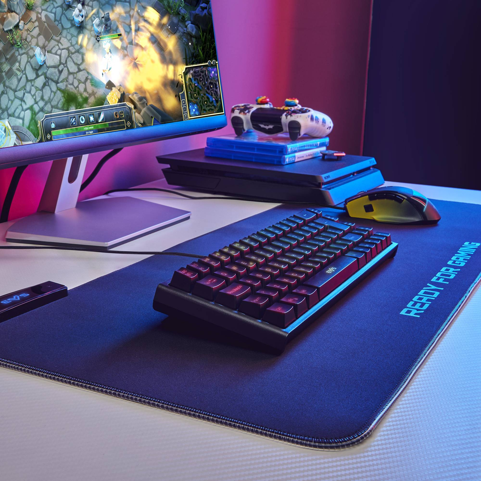 Configuración gaming con teclado, ratón y monitores mostrando un juego.