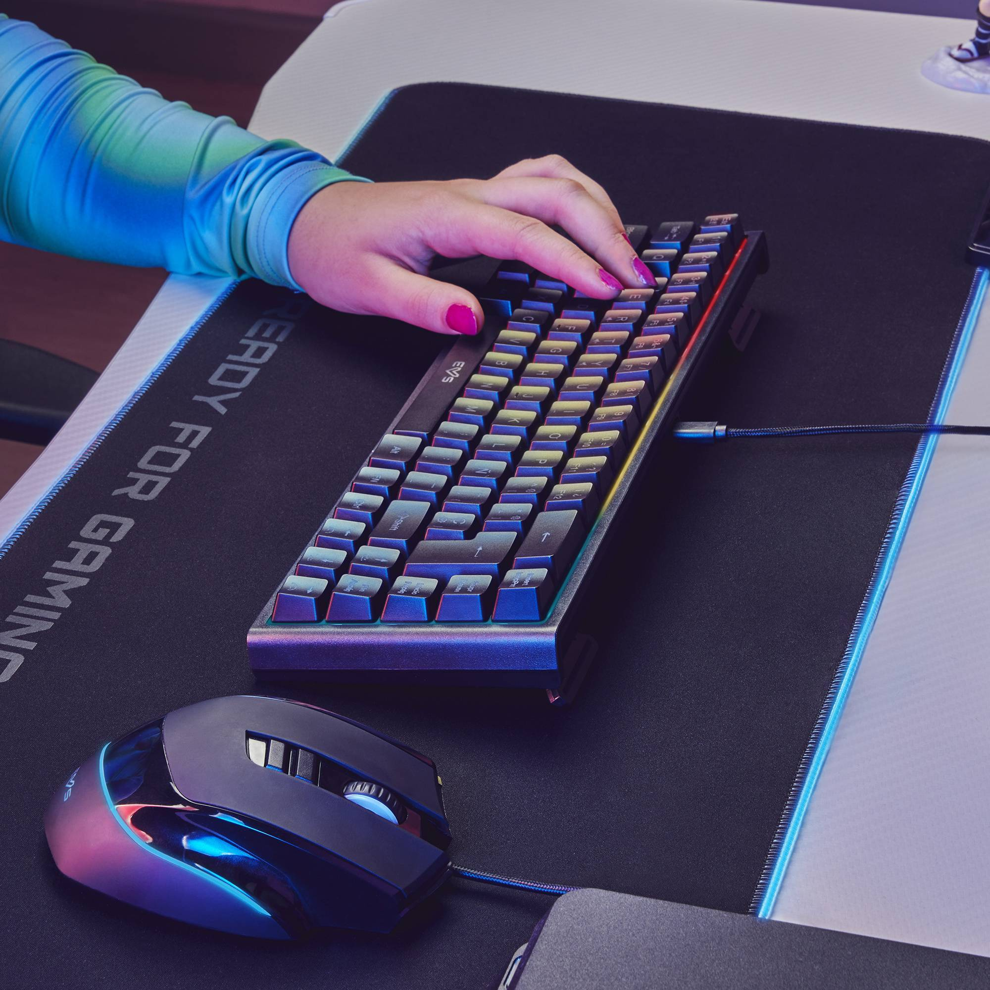 Configuración gaming: teclado con luces RGB, ratón y alfombrilla con tema gaming.
