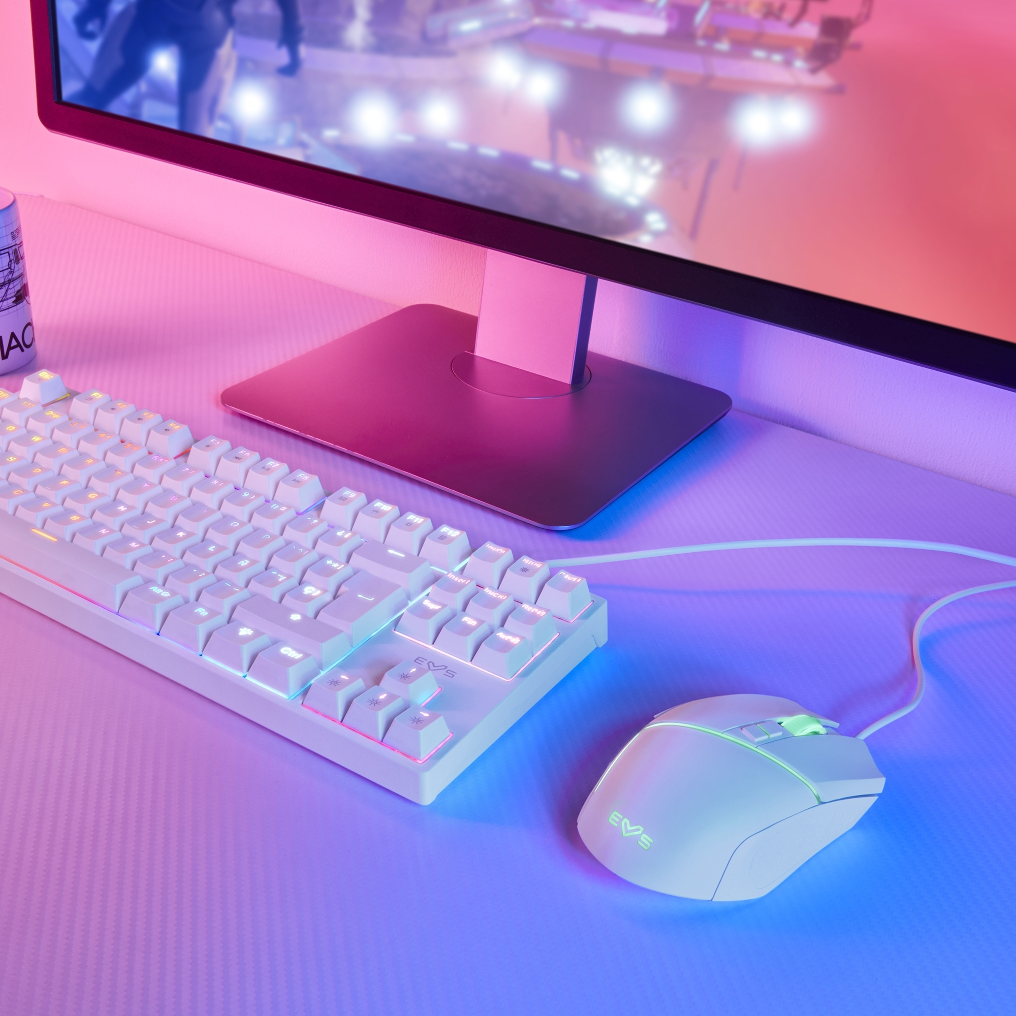 Configurazione di gioco con tastiera, mouse e monitor bianchi con illuminazione colorata.