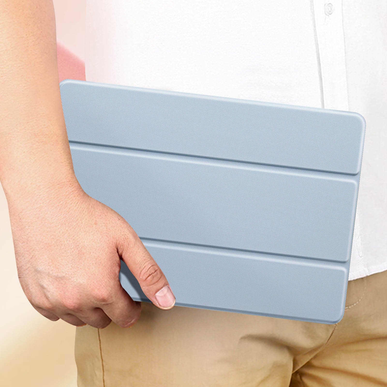 Persona che tiene una custodia per tablet azzurra con superficie strutturata, ripresa ravvicinata.