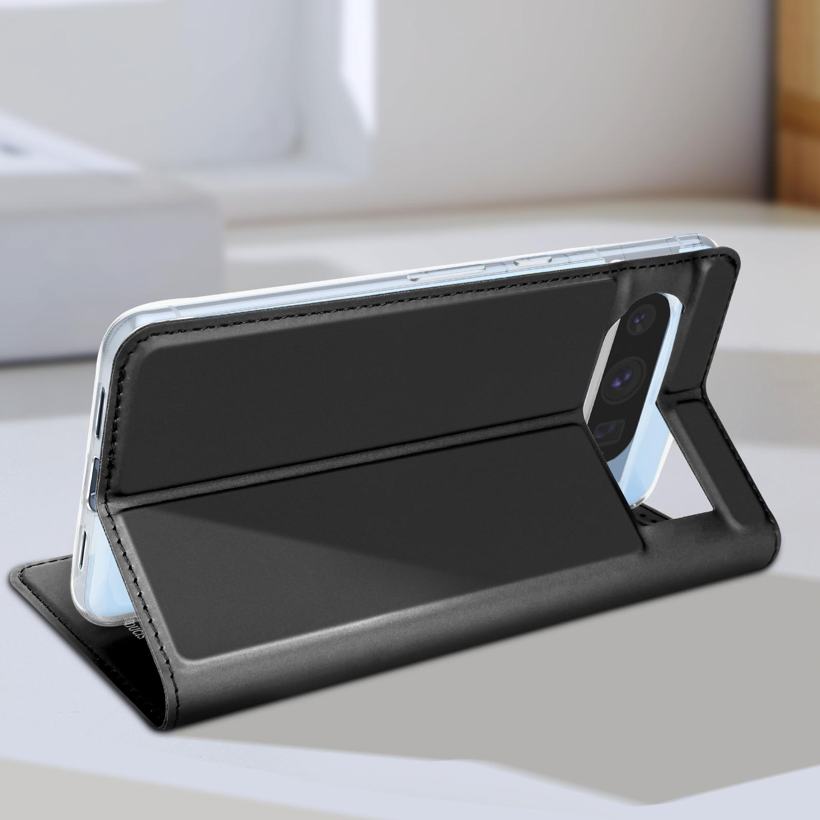 Étui de téléphone noir, ouvert, montrant un smartphone. Il est sur une surface blanche. Le téléphone est noir.