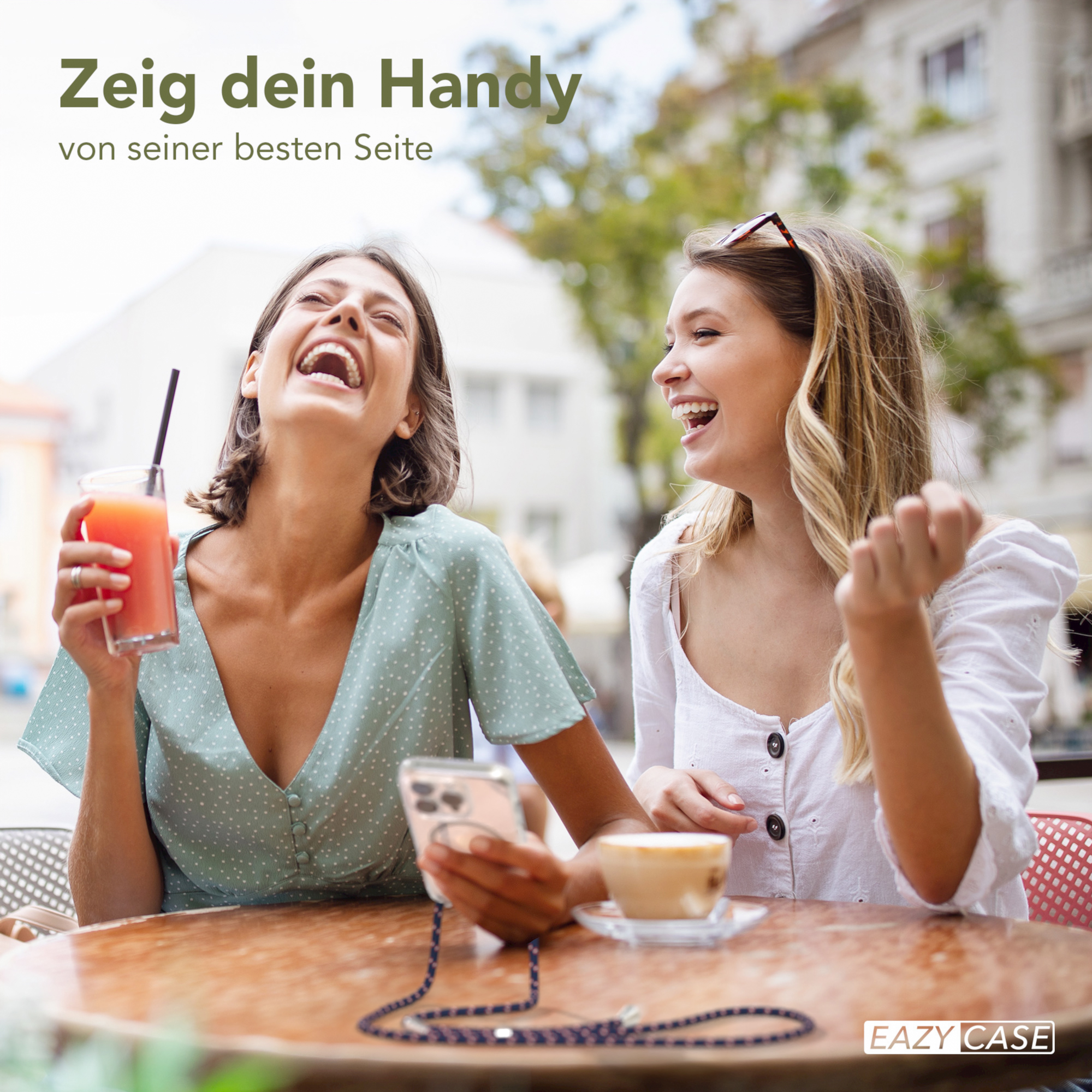 Zwei lachende Frauen, eine hält ein Telefon.