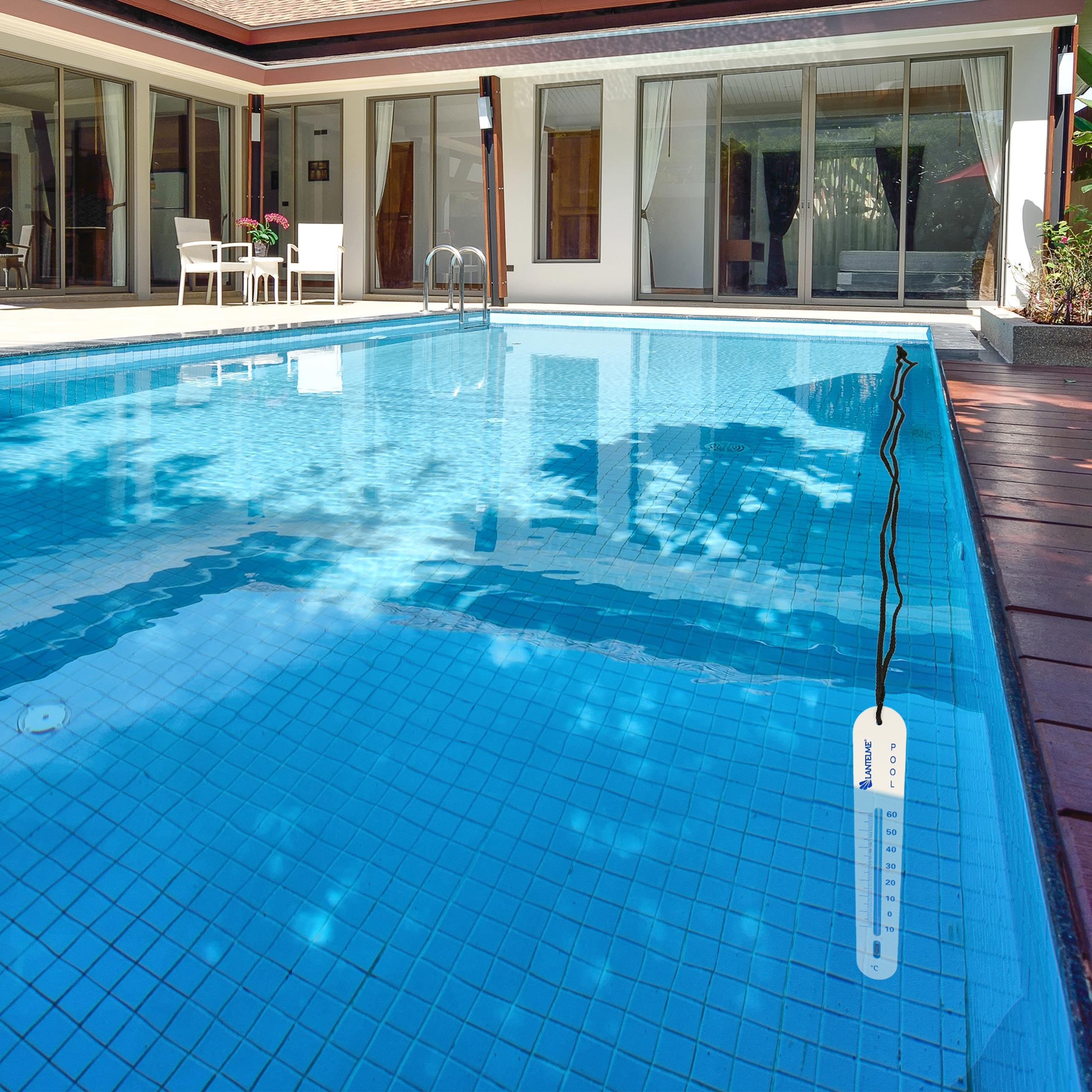 Schwimmbad mit blauen Fliesen. Pool hat ein Thermometer. Villa im Hintergrund.