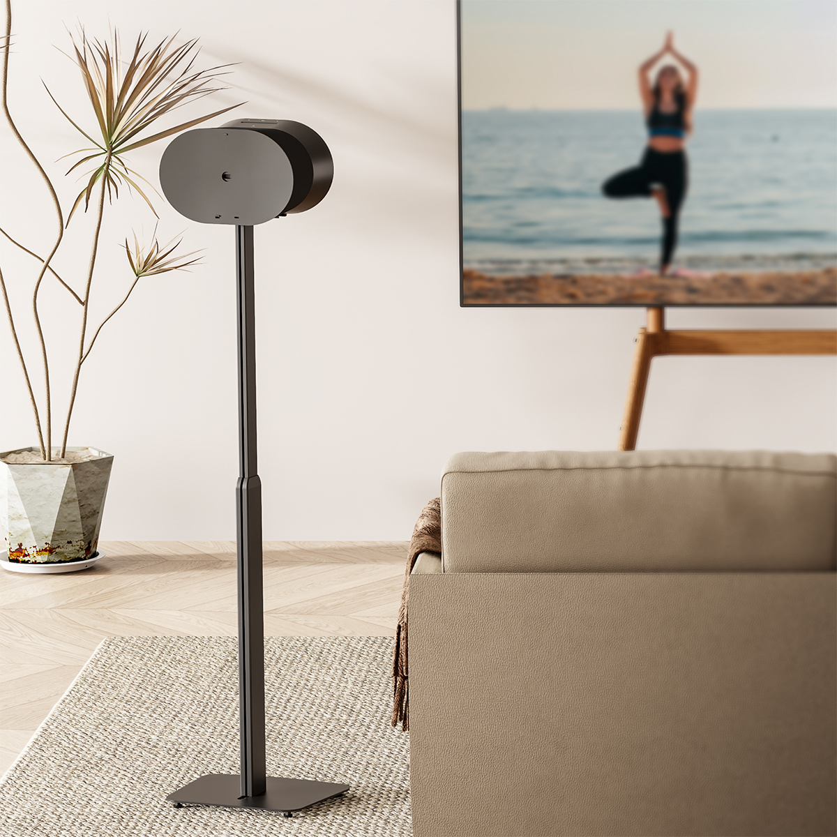Lautsprecher auf Ständer neben Sofa. Im Hintergrund Yoga am Strand.