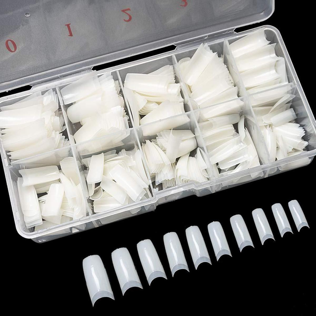 Eine transparente Plastikbox gefüllt mit künstlichen Nägeln in verschiedenen Formen und Größen.