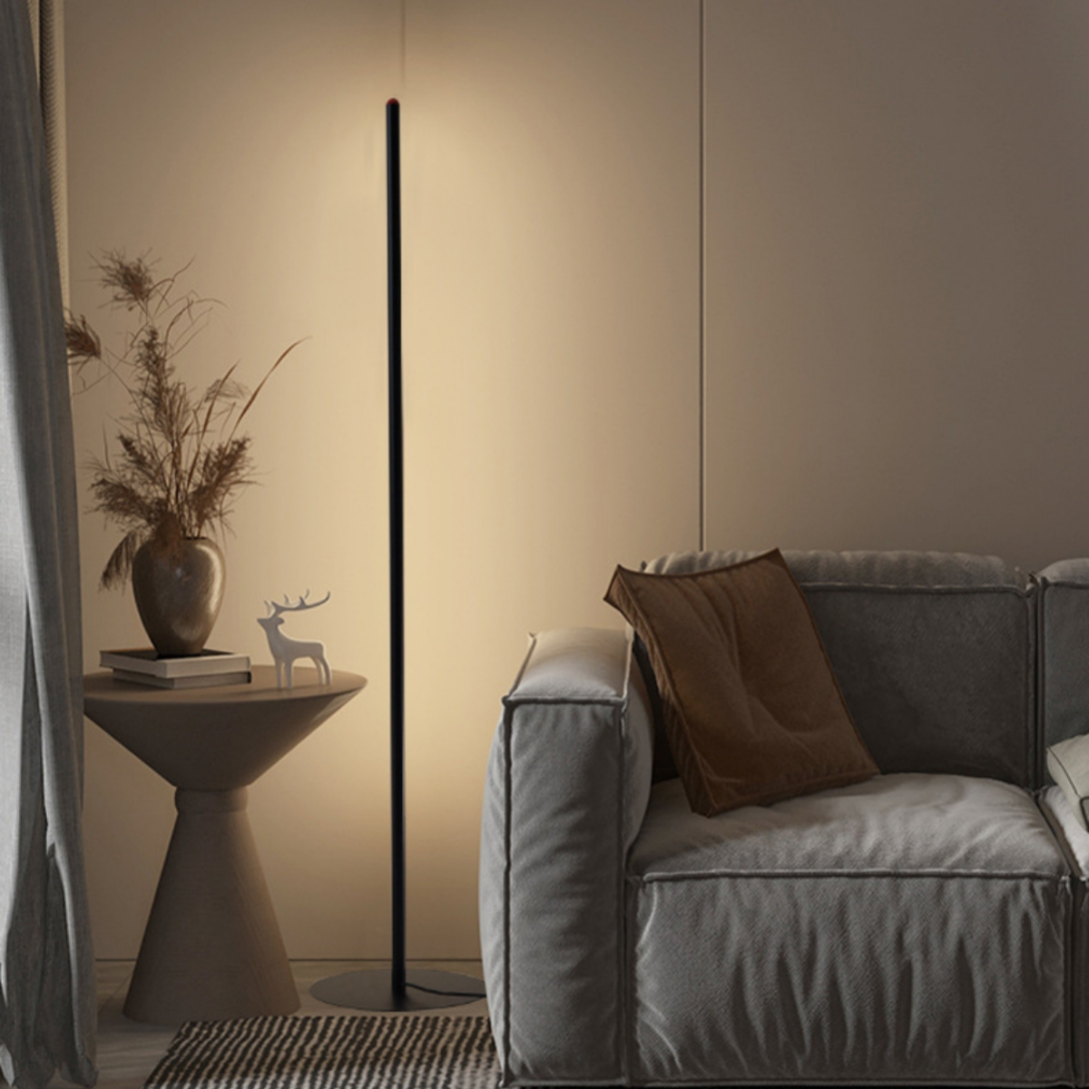 Moderne schwarze Stehlampe mit Licht. Vase und Hirschstatue auf dem Tisch.