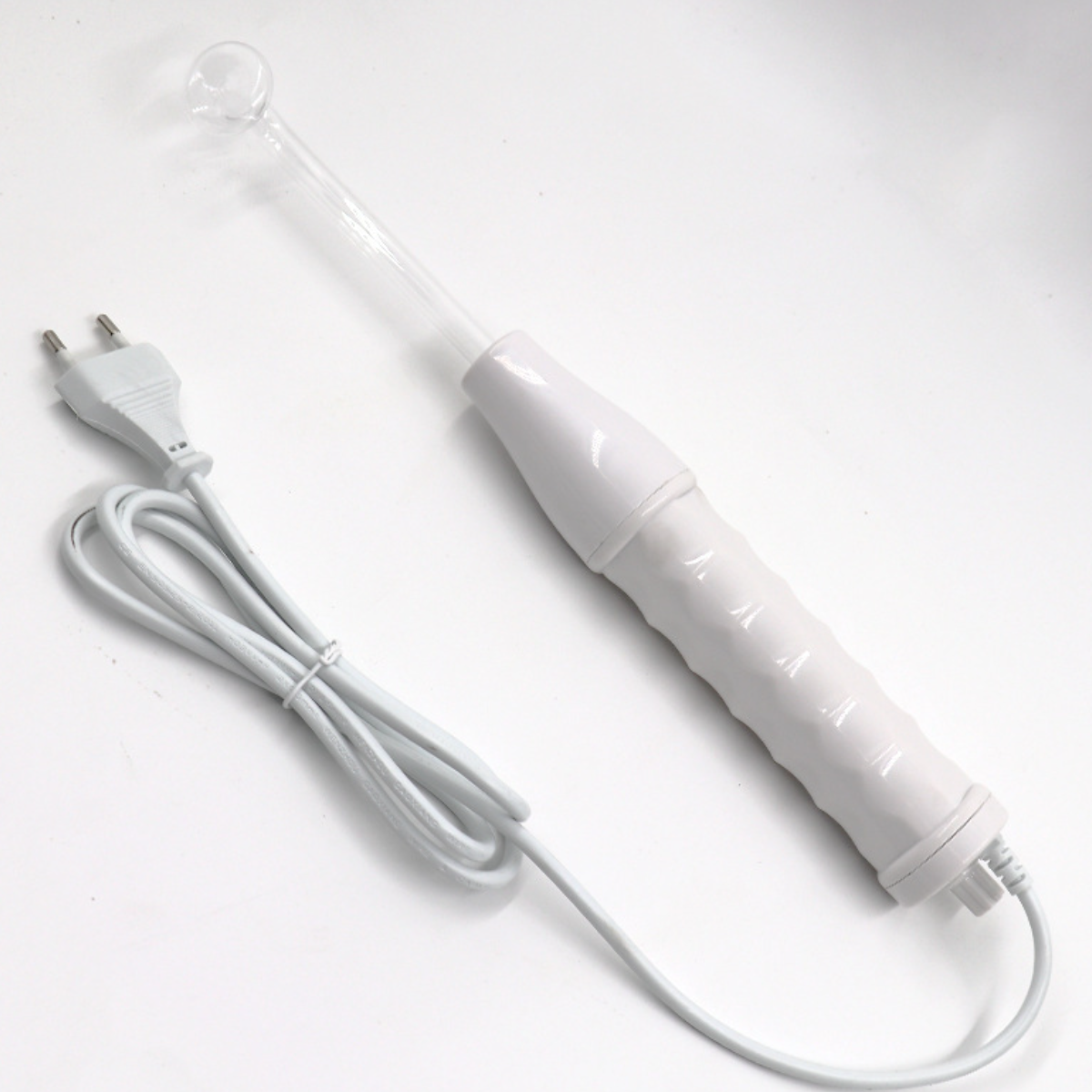 Ein weißer Hochfrequenz-Therapiestab mit Kabel. Der Stab ist oben klar.