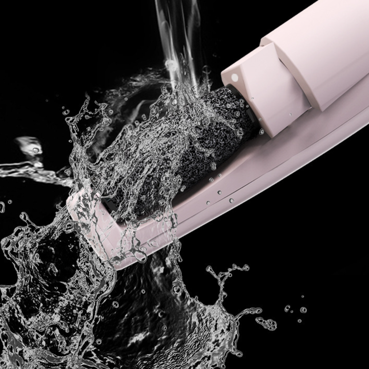Wasser spritzt auf ein rosa Gerät. Das Gerät scheint ein Fußpflege-Werkzeug zu sein. Schwarzer Hintergrund.