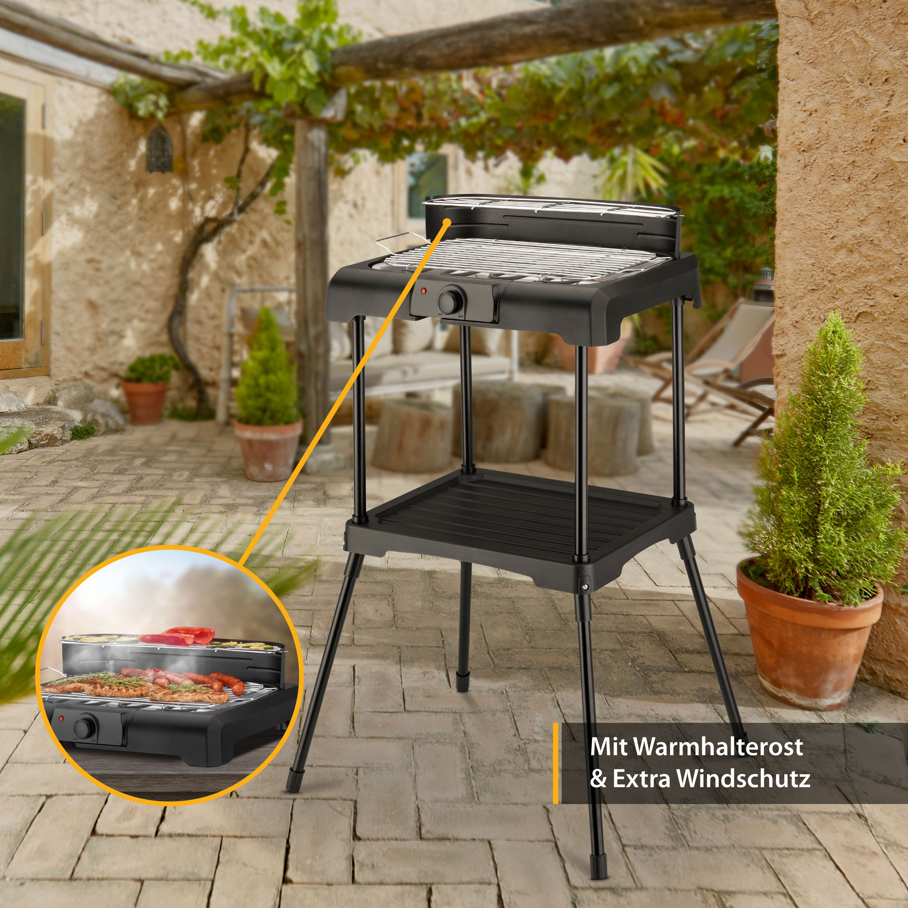 Ein schwarzer Elektrogrill mit Warmhalterost und Windschutz, gezeigt in einer Umgebung im Freien.