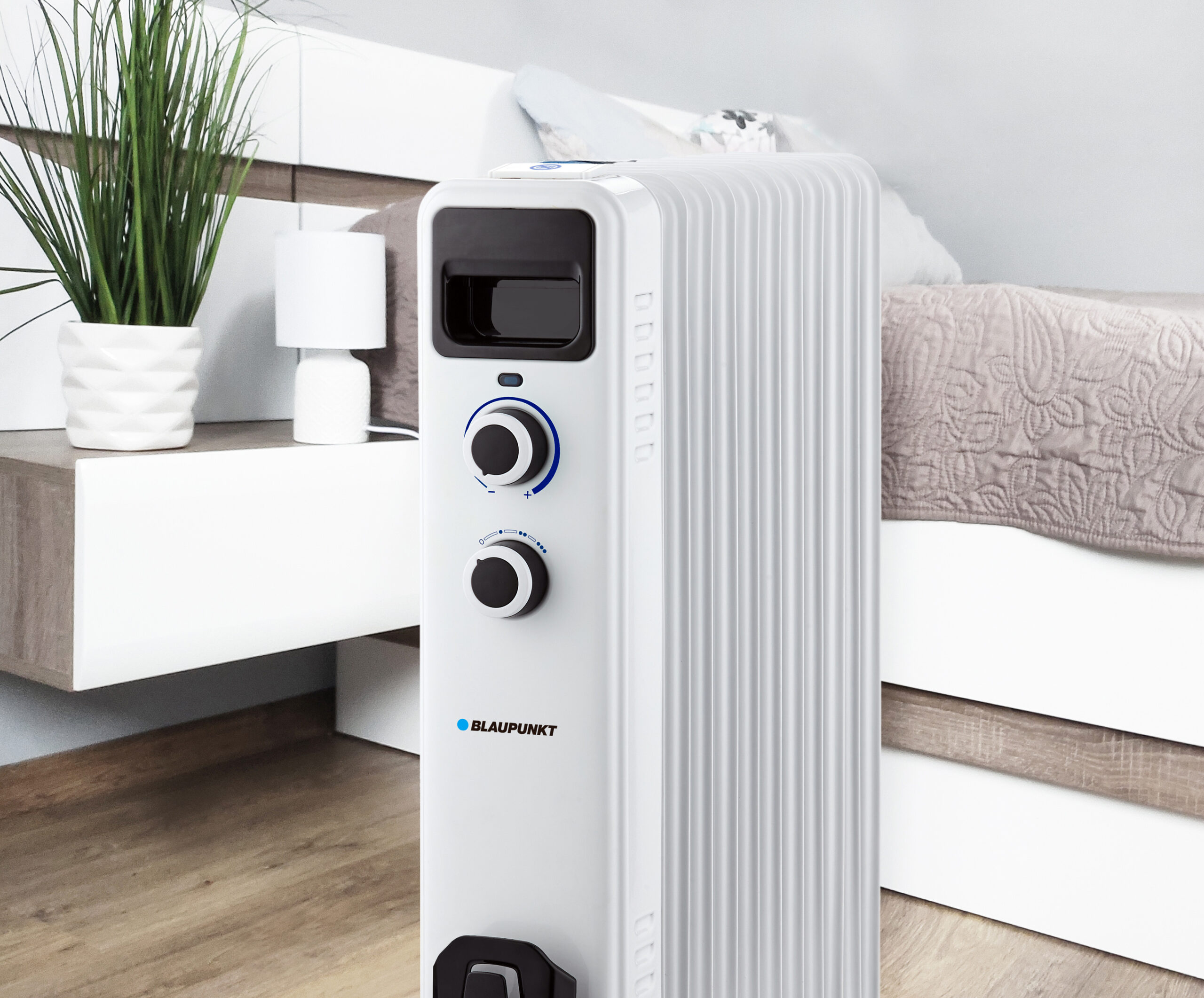 Radiatore elettrico bianco, con comandi, in un ambiente domestico.