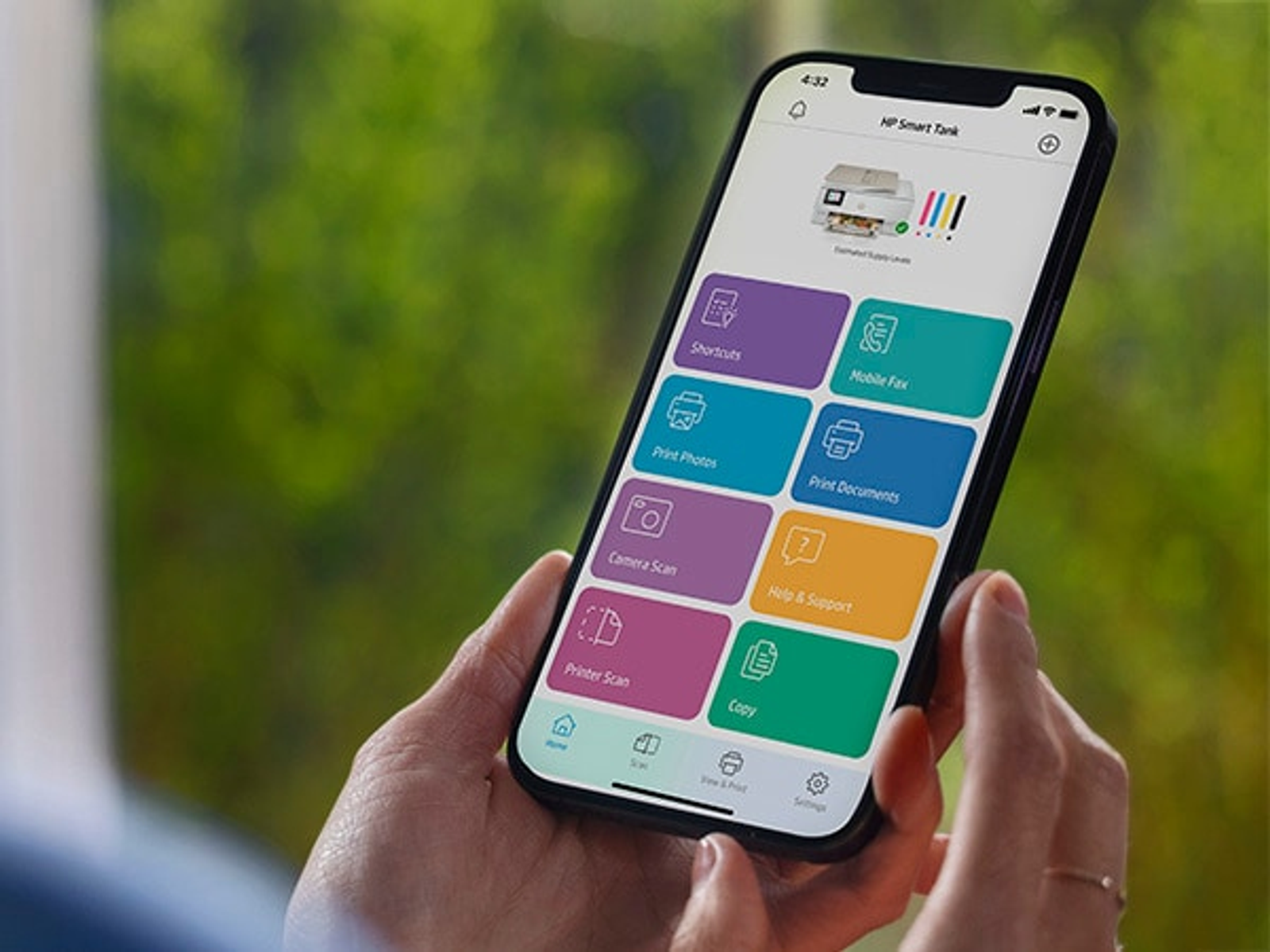 Ręka trzymająca telefon z interfejsem aplikacji HP Smart Tank.