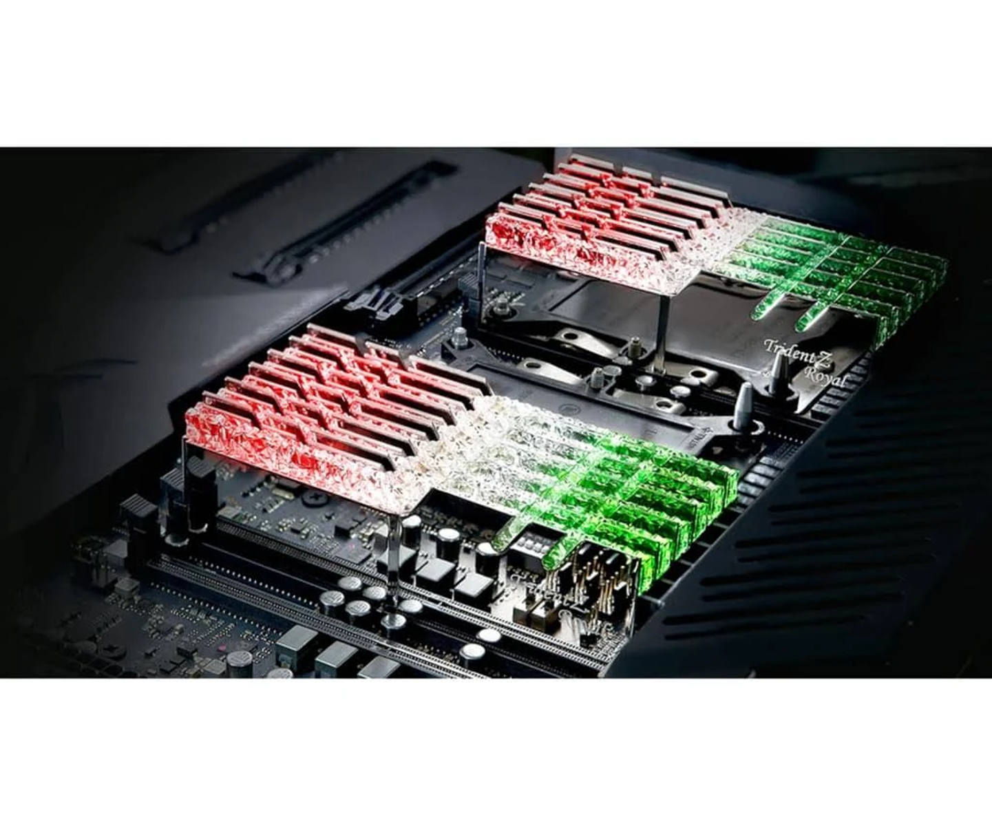 Płyta główna komputera z czerwonymi i zielonymi światłami LED na gniazdach RAM. Logo 'Trident Z Royal' jest widoczne.