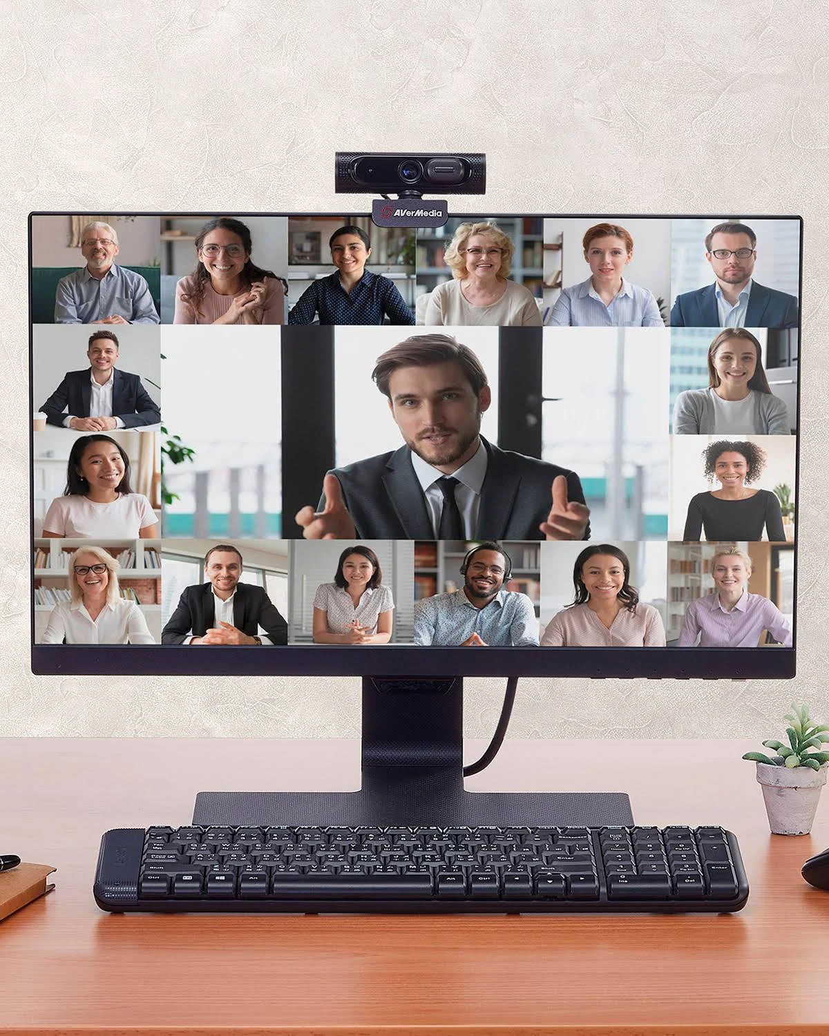 Moniteur affiche une vidéoconférence avec beaucoup de personnes. Webcam montée au-dessus.
