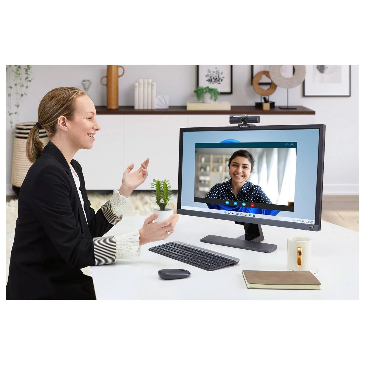 Kobieta podczas rozmowy wideo na komputerze z monitorem i kamerą internetową.