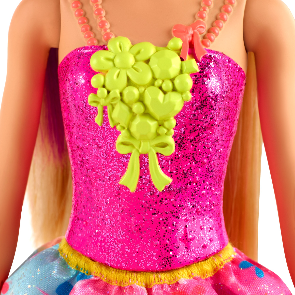 Nahaufnahme des Oberteils der Barbie-Puppe. Rosa Pailletten-Oberteil mit grünen Blumen- und Schleifenakzenten.