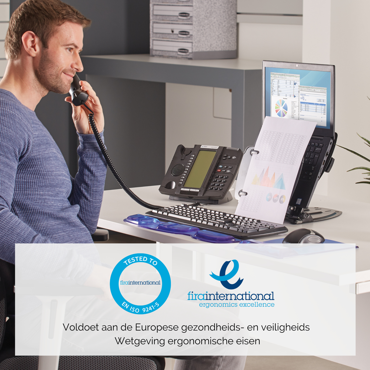 Mężczyzna przez telefon przy biurku. Biurko z dokumentami, monitorem, telefonem i logo ergonomii.