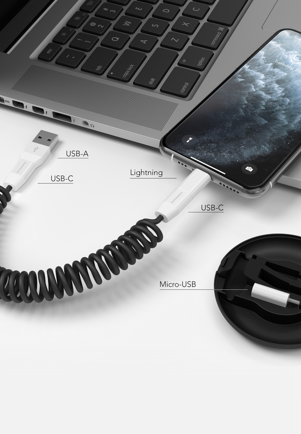 Vari cavi di ricarica: USB-A, USB-C, Lightning e Micro-USB, collegati a laptop e telefono.
