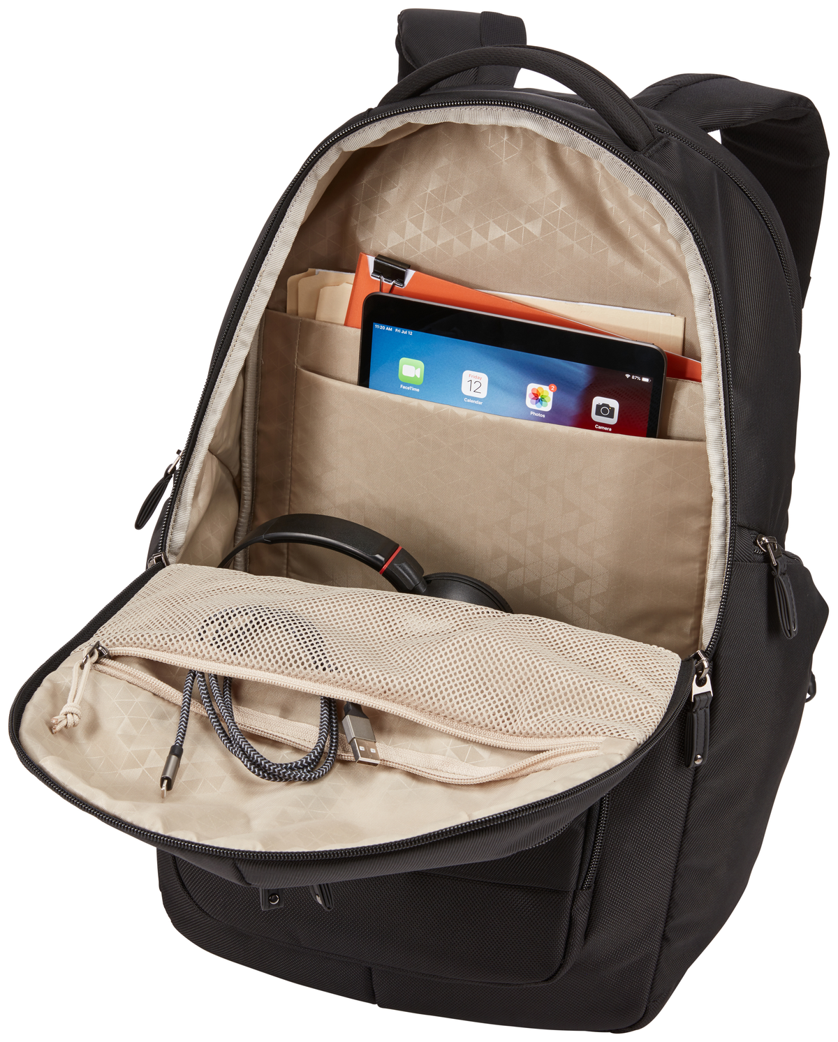 Ein schwarzer Rucksack, offen. Innen sind ein Tablet, Kopfhörer und Dokumente sichtbar.