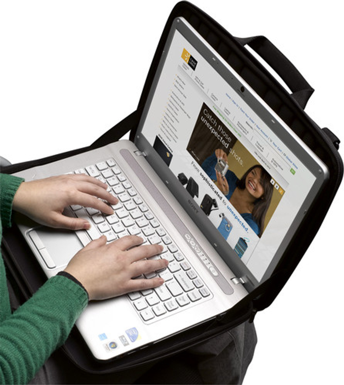 A person working on a silver laptop in a black case. The laptop screen displays a website.