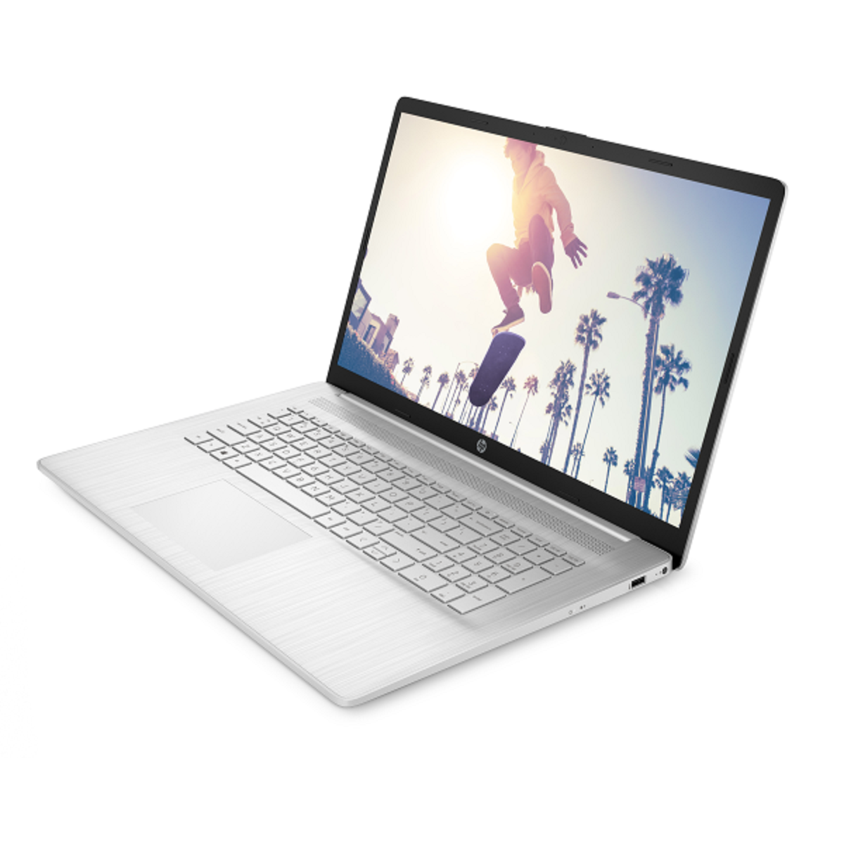Ein silberner Laptop, der auf einer weißen Oberfläche geöffnet ist. Der Bildschirm zeigt einen Skateboarder in der Luft.