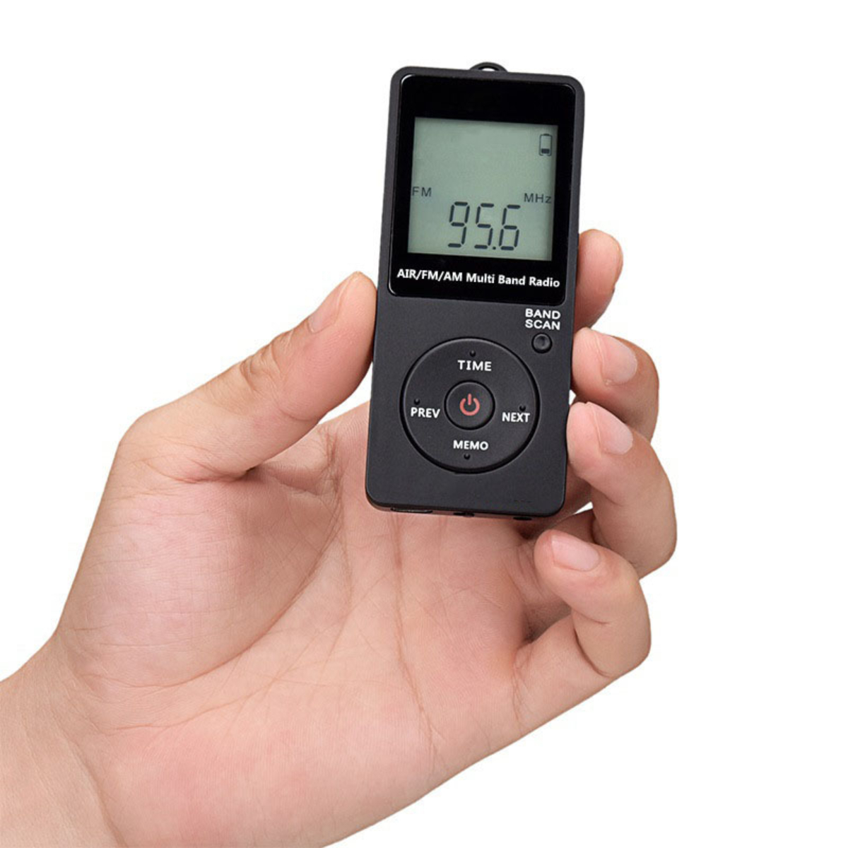 Eine Hand, die ein schwarzes tragbares Radio mit Tasten und einem Bildschirm hält, der "95.6 MHz" auf weißem Hintergrund anzeigt.