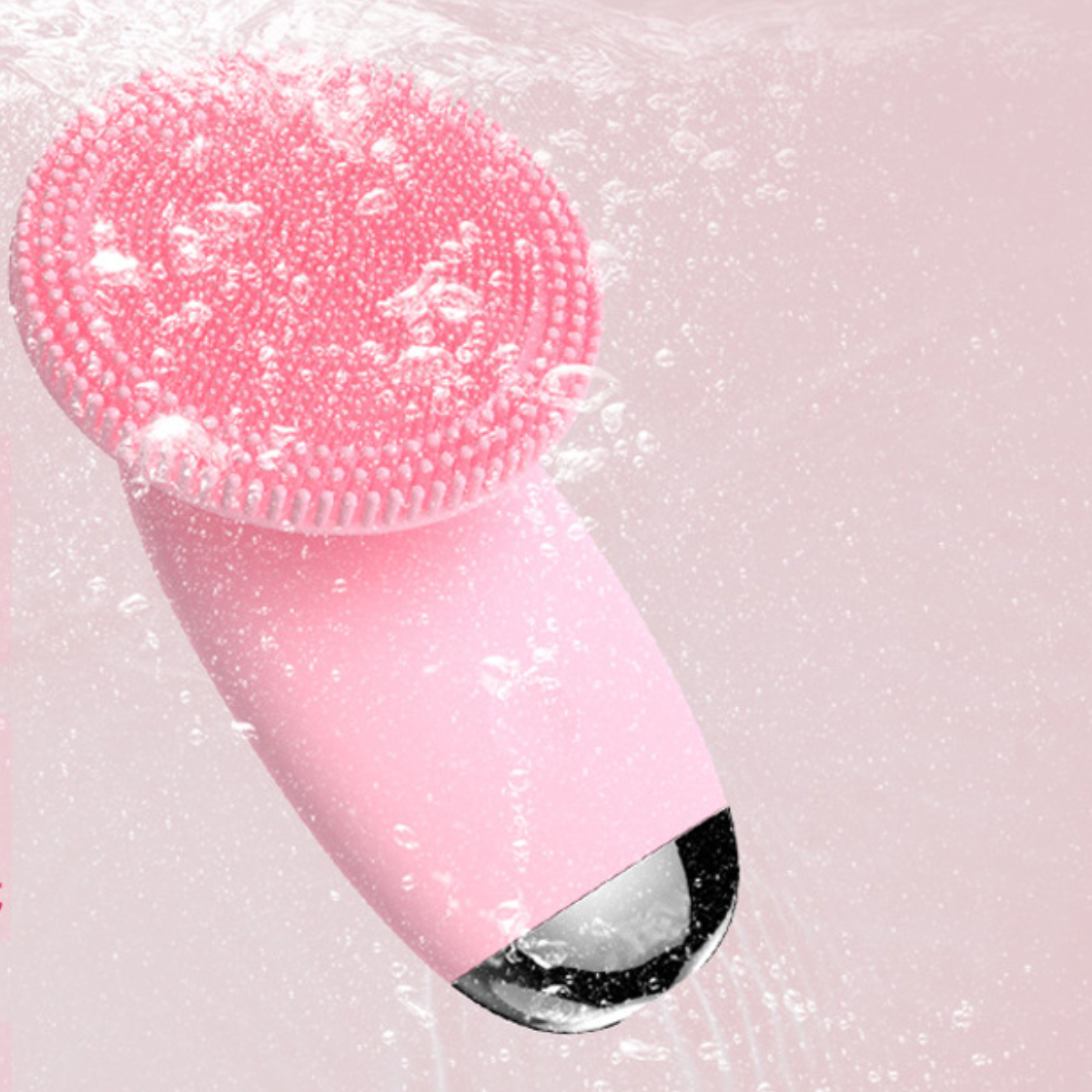 Eine rosa Gesichtsbürste mit rundem Bürstenkopf und silbernem Sockel, mit Wassertropfen.