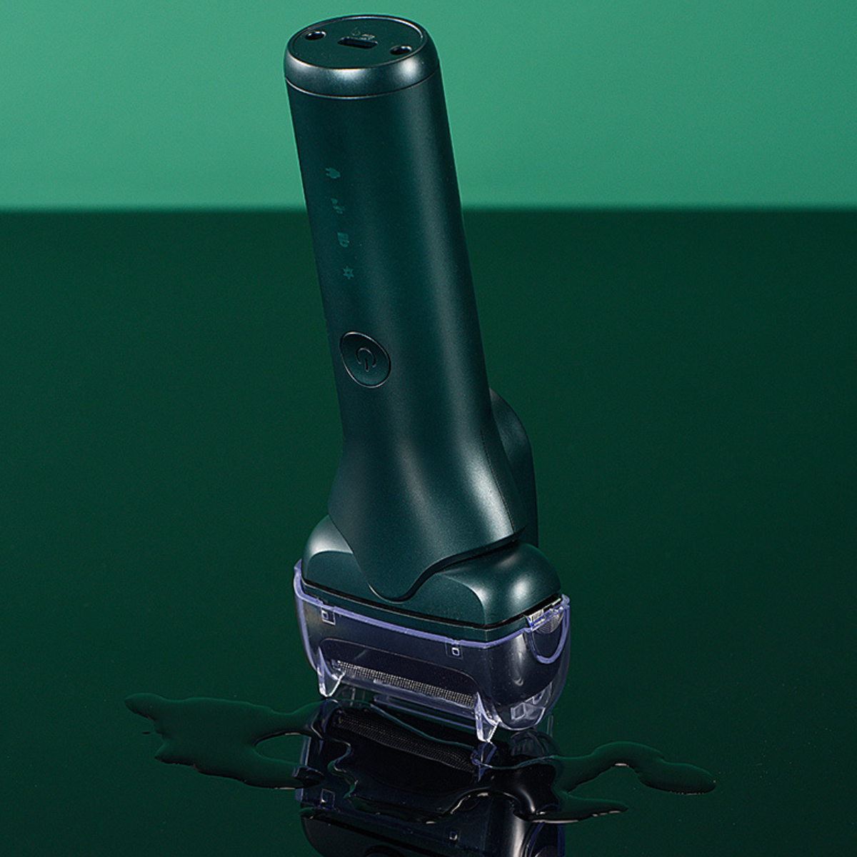 Grüner elektrischer Rasierer auf reflektierender Oberfläche, grüner Hintergrund. Wassertropfen sind sichtbar.