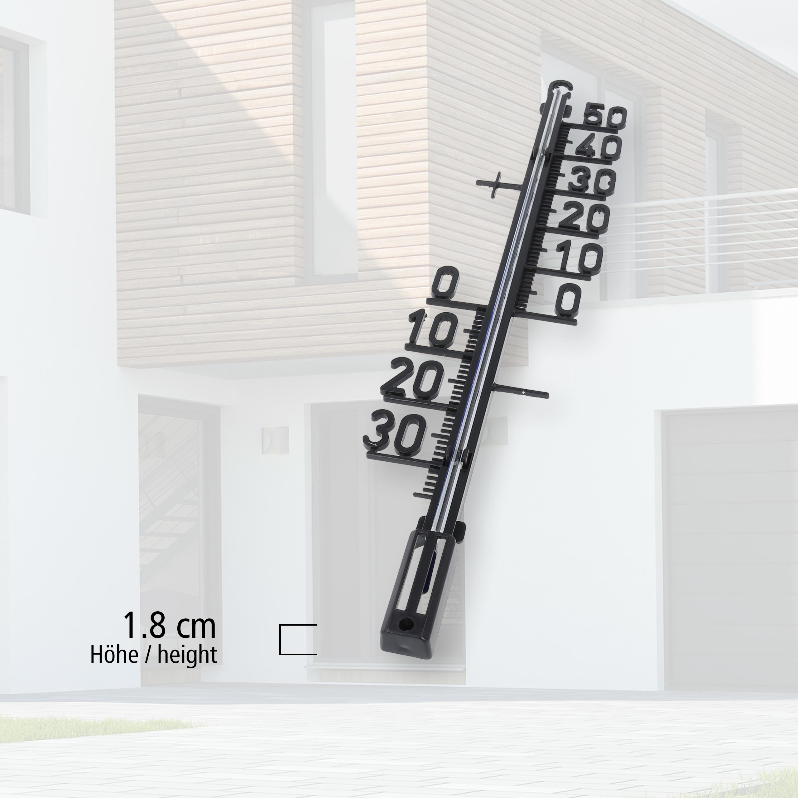 Außenthermometer an weißer Wand, zeigt Temperaturmesswerte an.
