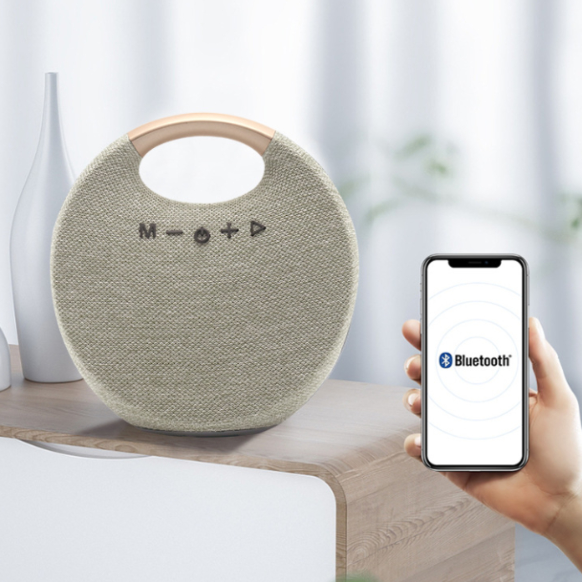 Beigefarbener Lautsprecher mit Holzgriff. Telefon mit Bluetooth-Symbol. Holztisch, weißer Hintergrund.