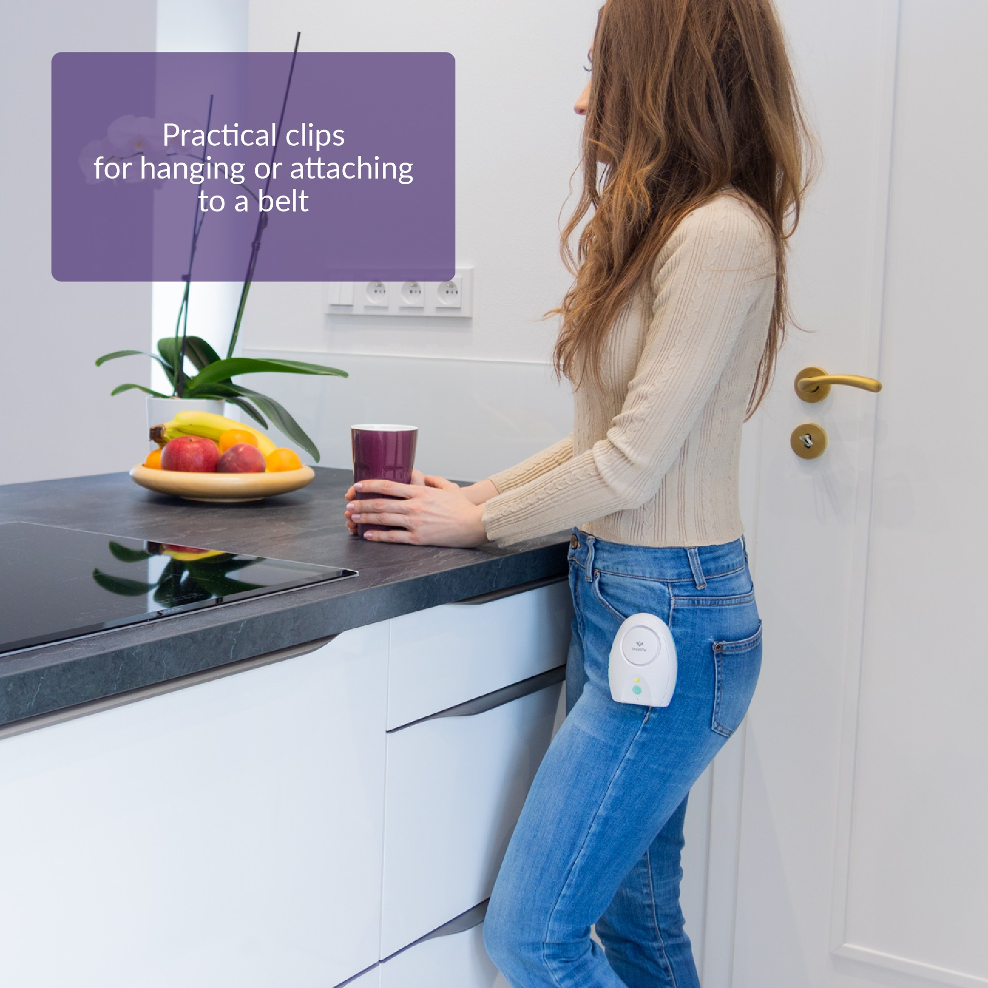 Frau mit Gerät an Jeans befestigt. Küchenumgebung mit Obst.