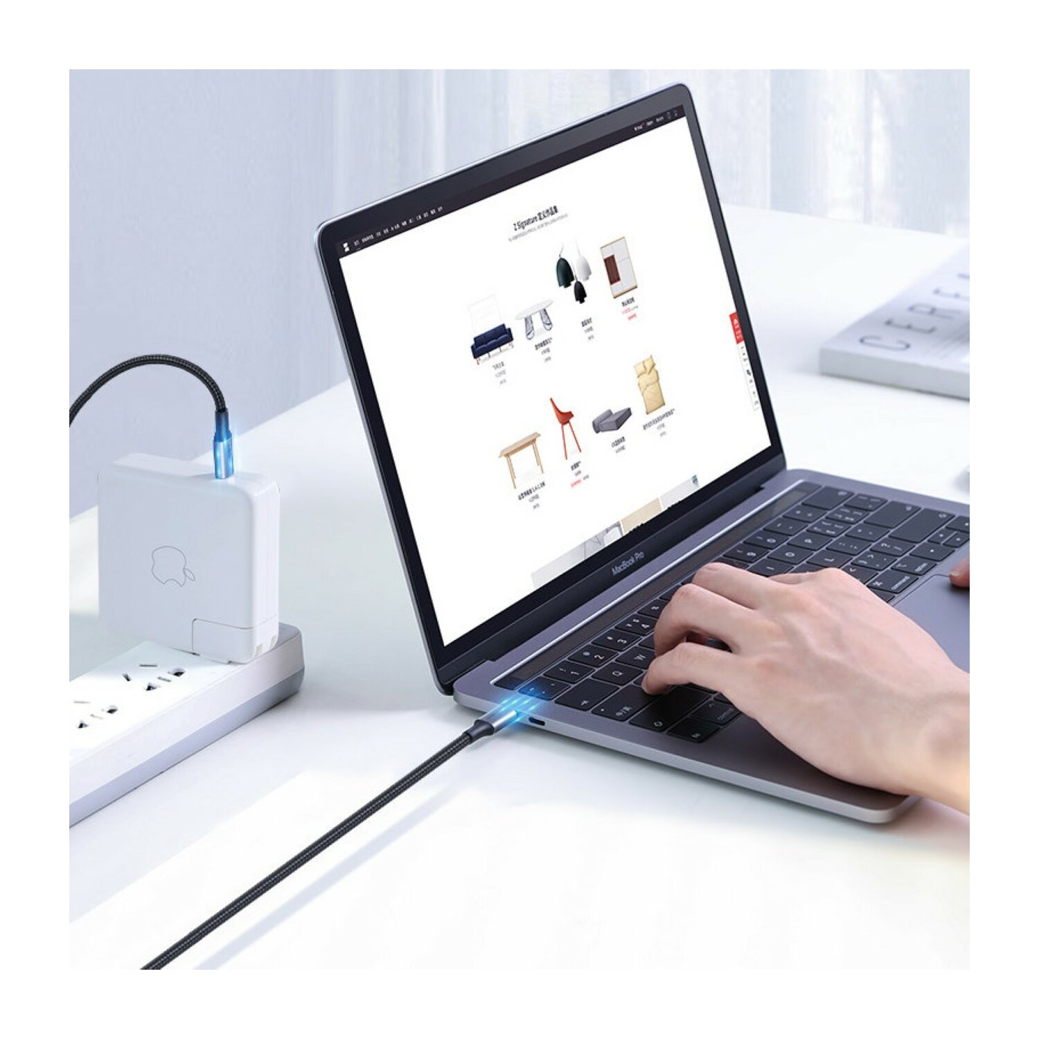 Laptop podłączony do zasilacza kablem USB-C, wyświetlający stronę internetową.