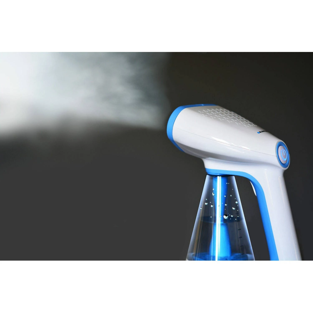 Ein weiß-blauer Dampfer sprüht Dampf. Der Hintergrund ist dunkelgrau.