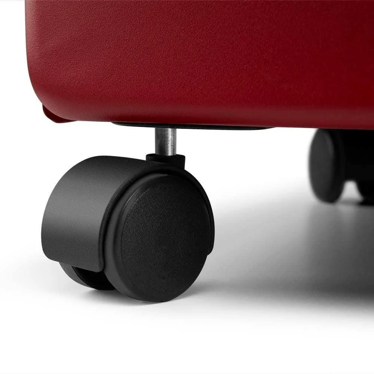 Un primo piano di una ruota nera con un oggetto rosso sullo sfondo.