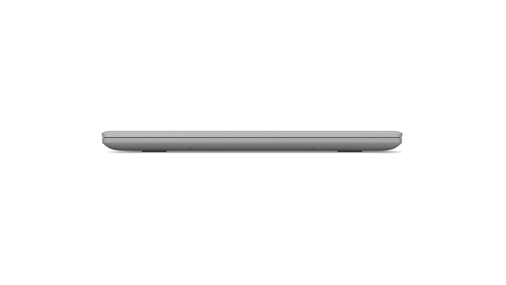 Ein grauer Laptop von der Seite gesehen, geschlossen, auf weißer Oberfläche.