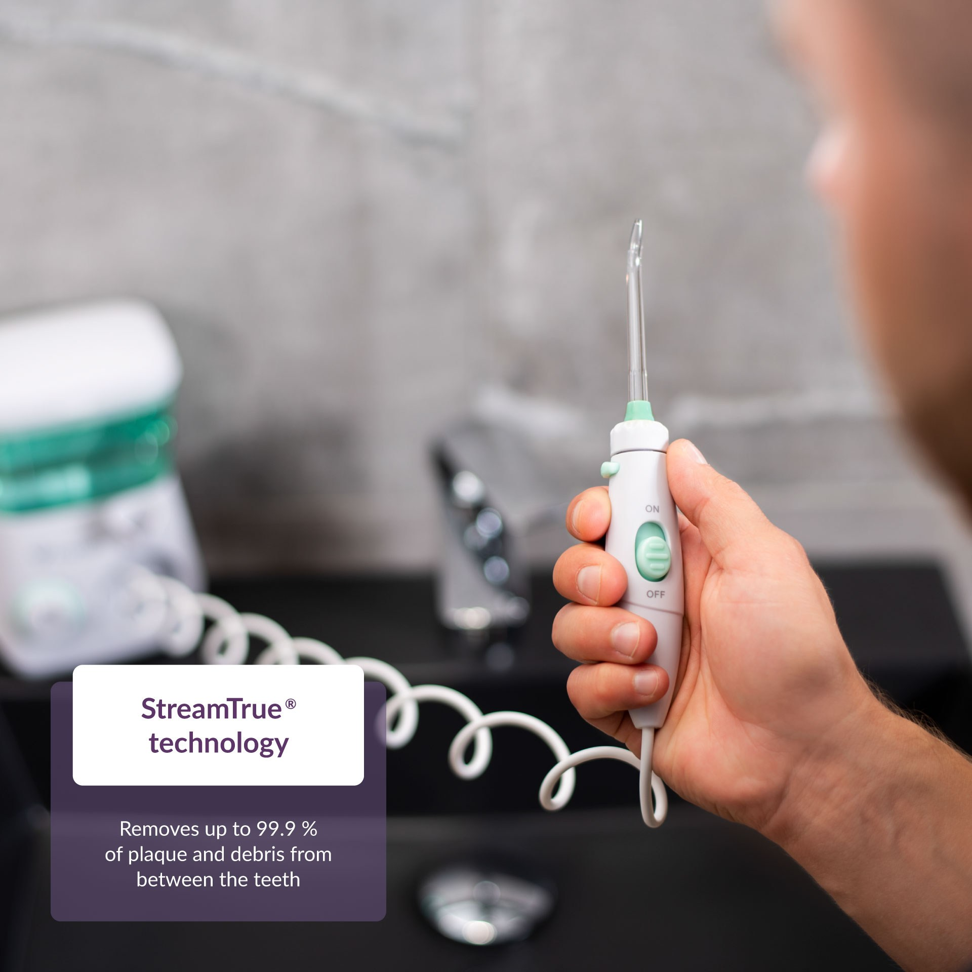 Hand hält einen weißen und grünen Wasser-Flosser. Textfeld mit Produktinformationen.