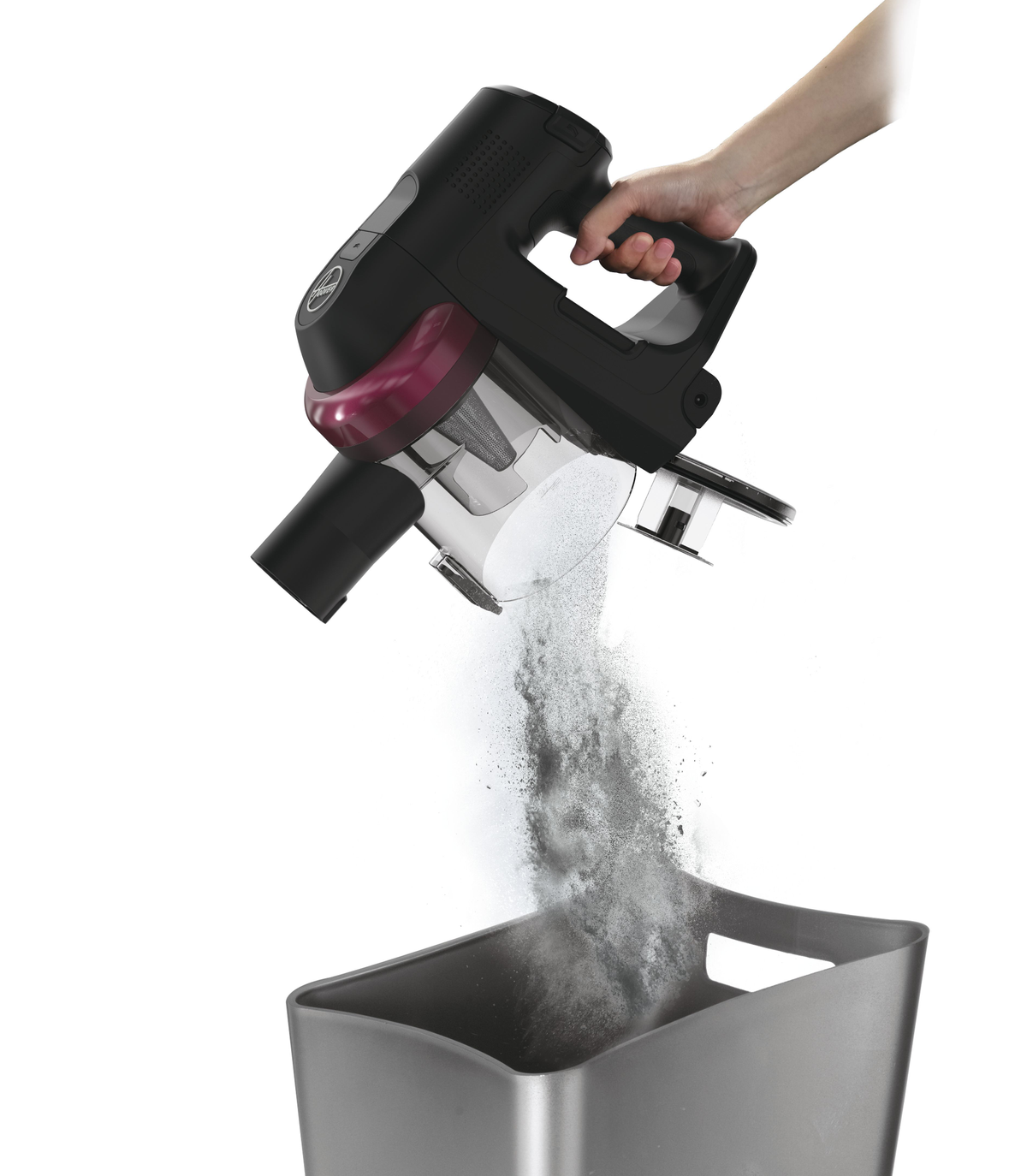 A vacuum cleaner pouring dust into a bin. Hand holding vacuum.