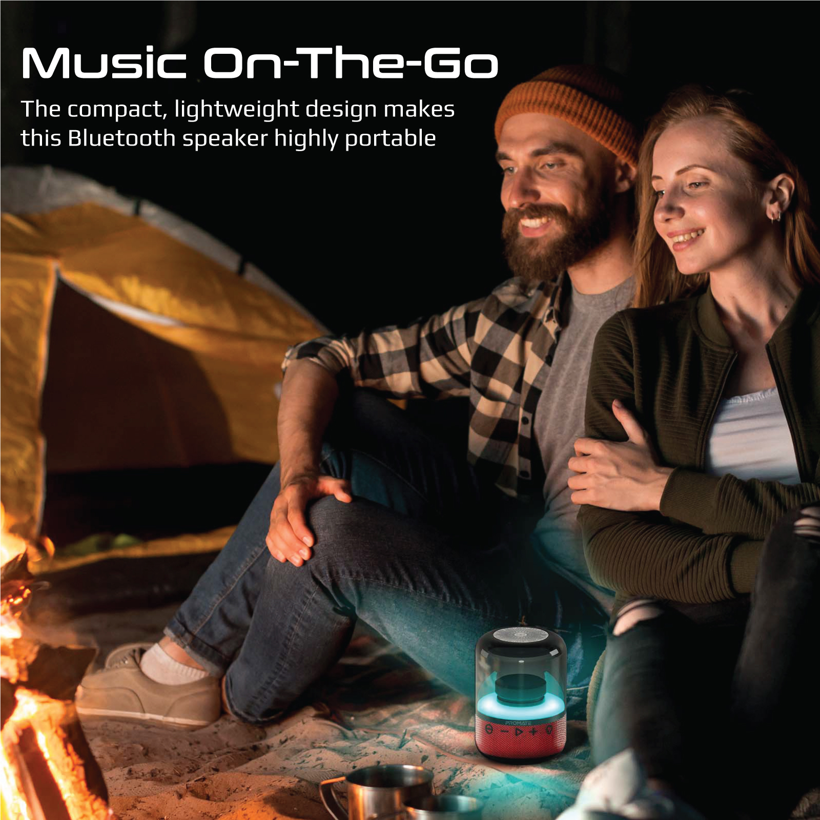 Una pareja se sienta cerca de un fuego, con un altavoz rojo. El texto en la imagen dice 'Music On-The-Go', un altavoz Bluetooth.