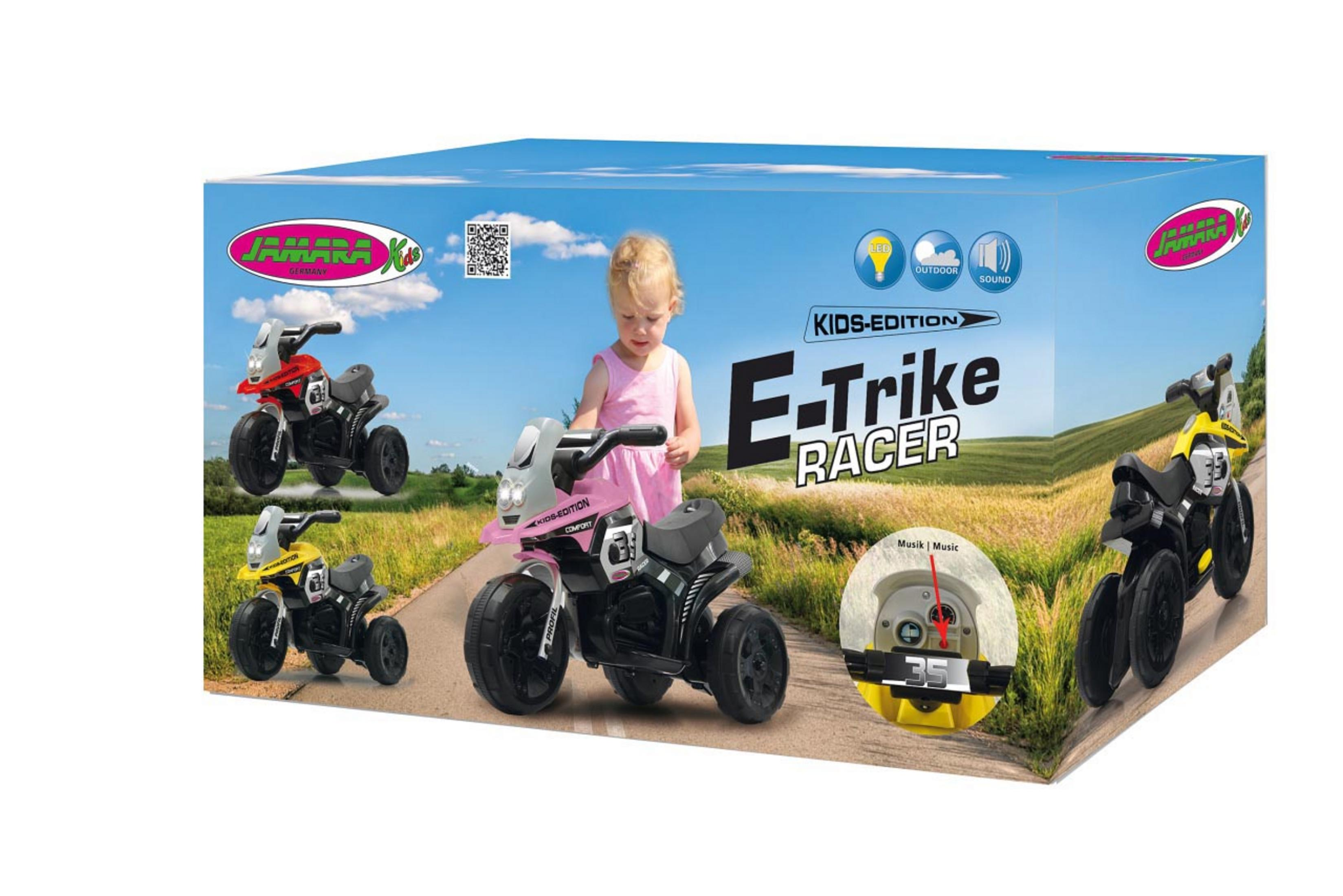 Karton mit Spielzeug-Dreirädern darauf. Ein Kind steht neben der Box. Die Box hat Text 'E-Trike Racer'.