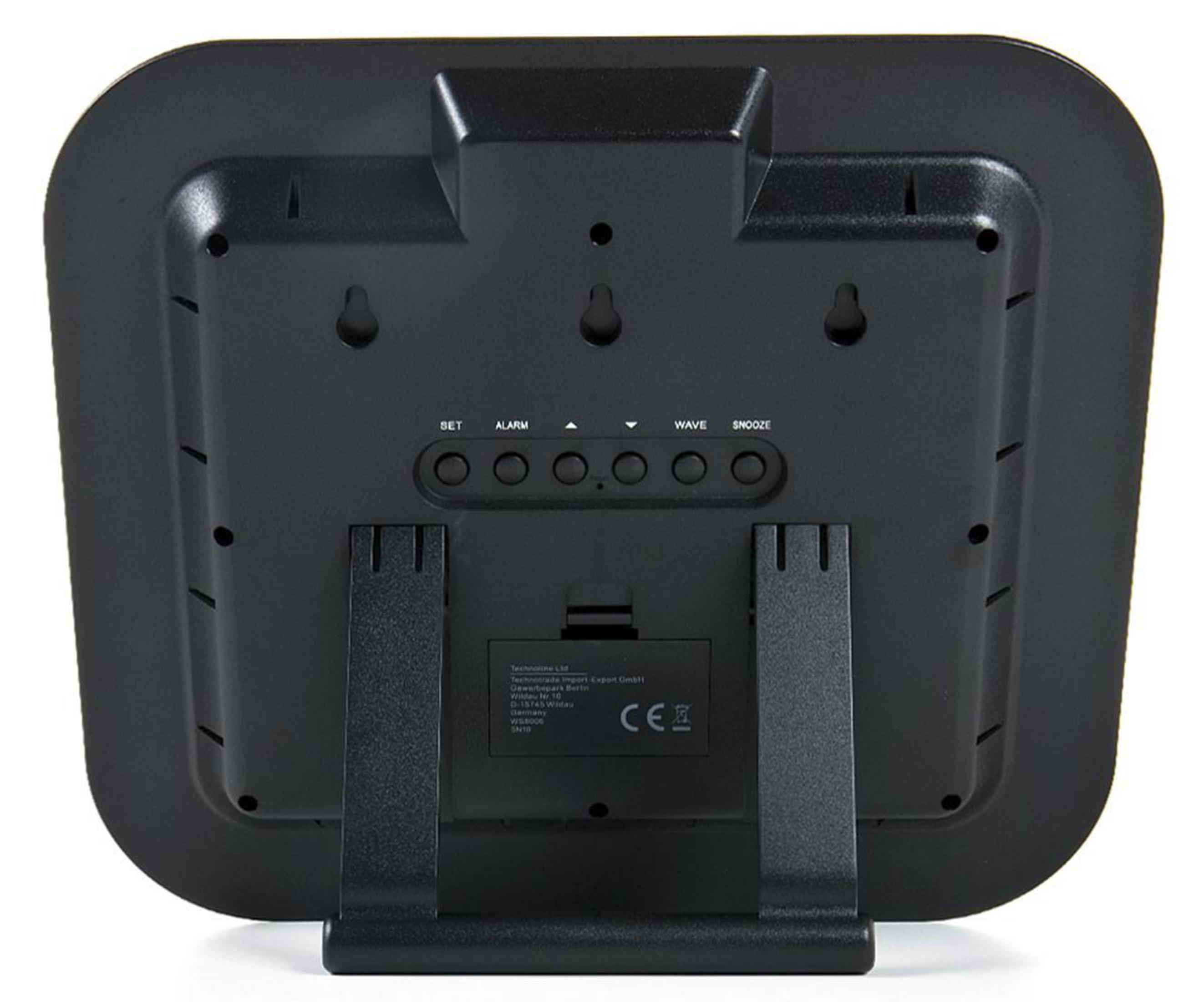 Czarny zegar cyfrowy z przyciskami z tyłu. Tarcza ma zakrzywioną konstrukcję.