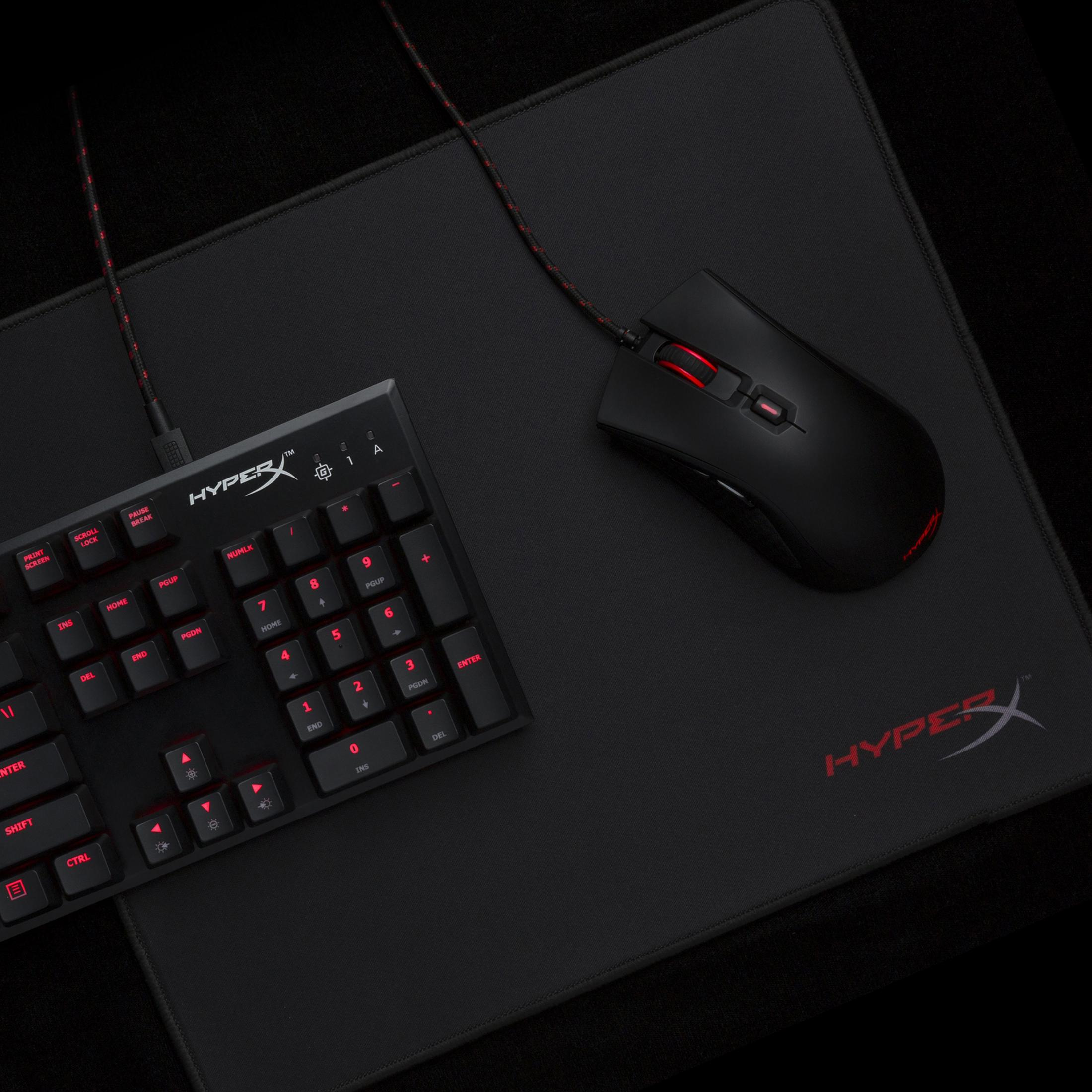 Czarna konfiguracja do gier: klawiatura, mysz i podkładka pod mysz z czerwonymi akcentami na czarnej powierzchni.
