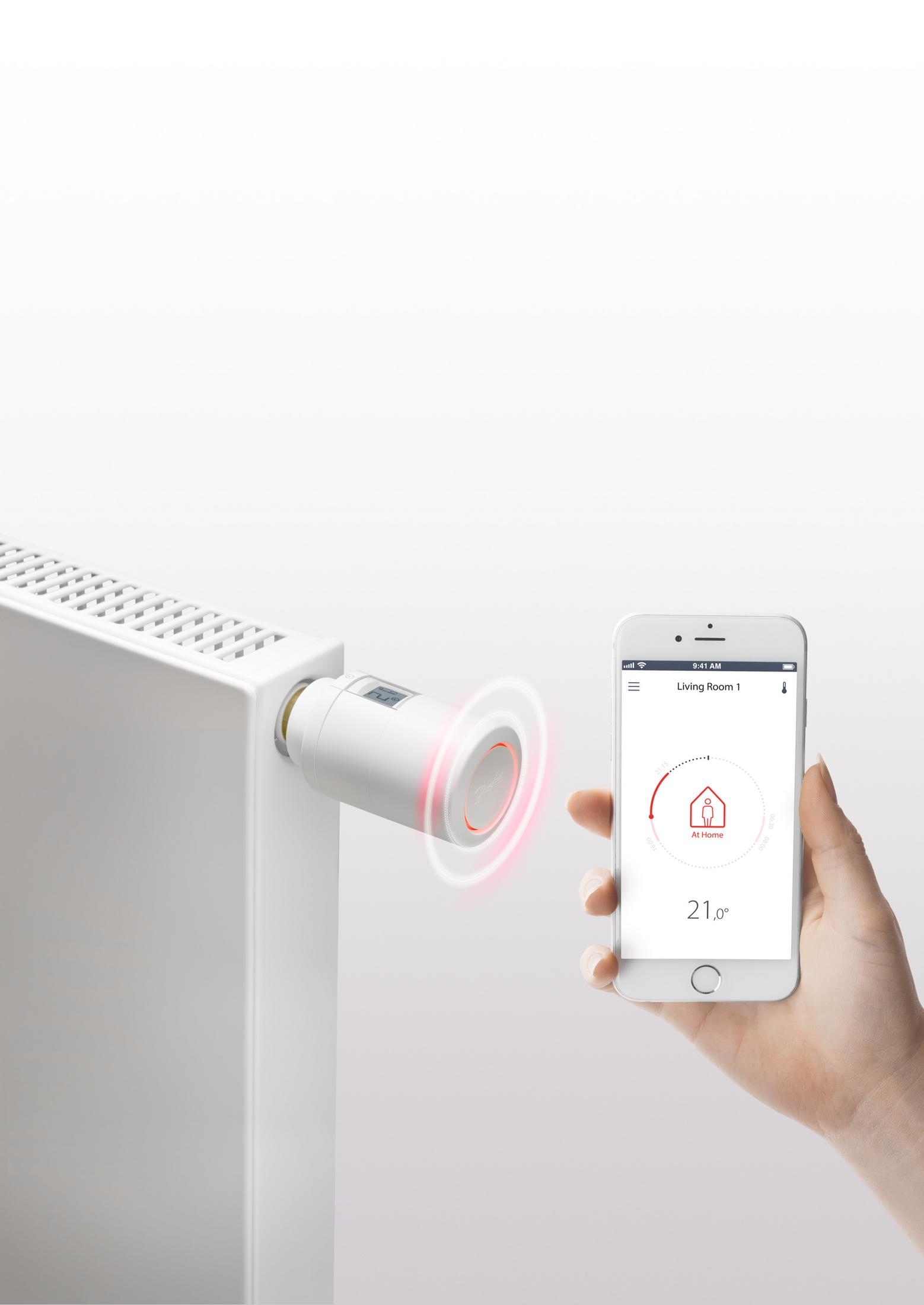 Smart-Thermostat an einem Heizkörper, gesteuert vom Telefon.