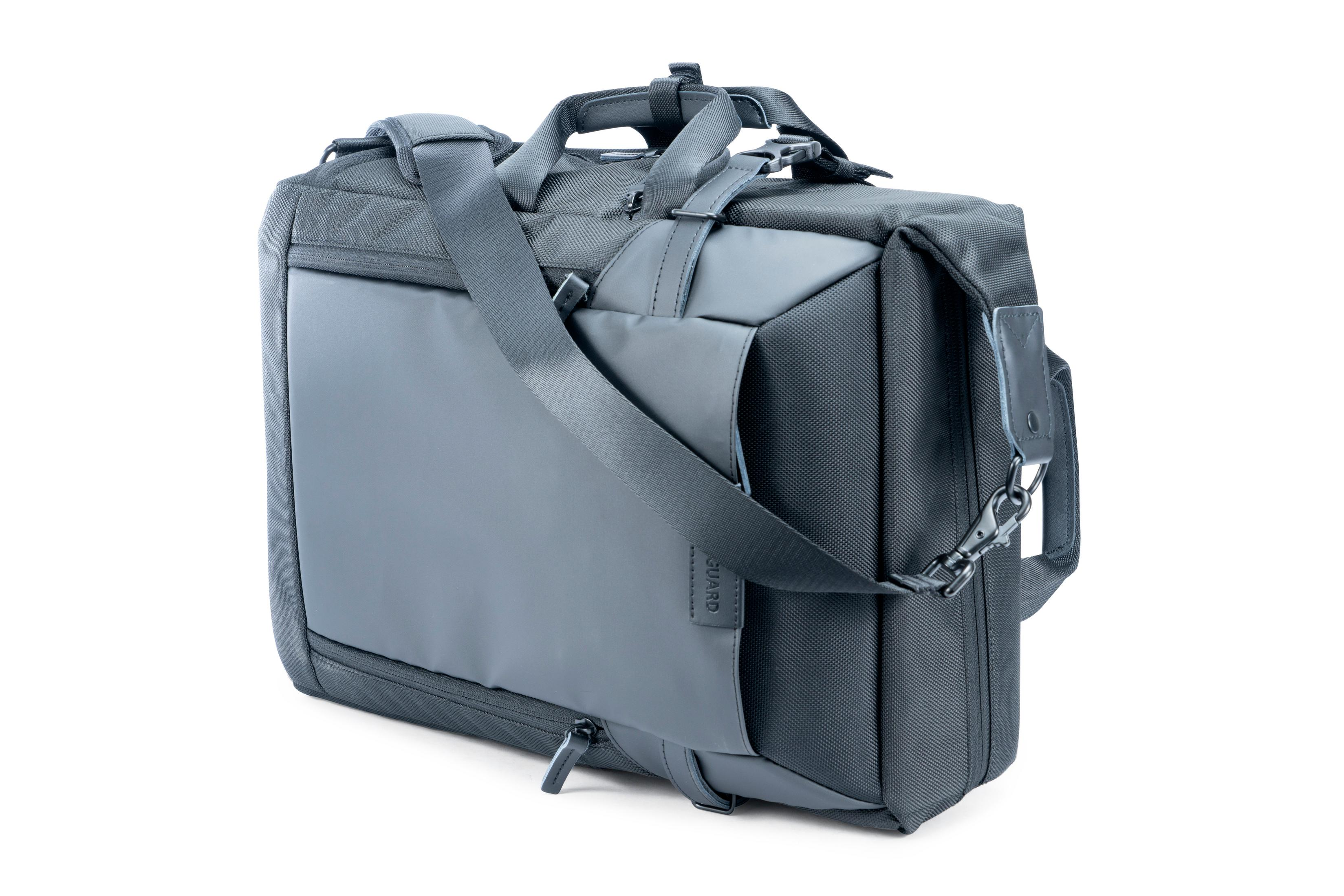 Graue Laptoptasche mit mehreren Taschen, Schultergurt und Griff. Guard-Logo sichtbar.