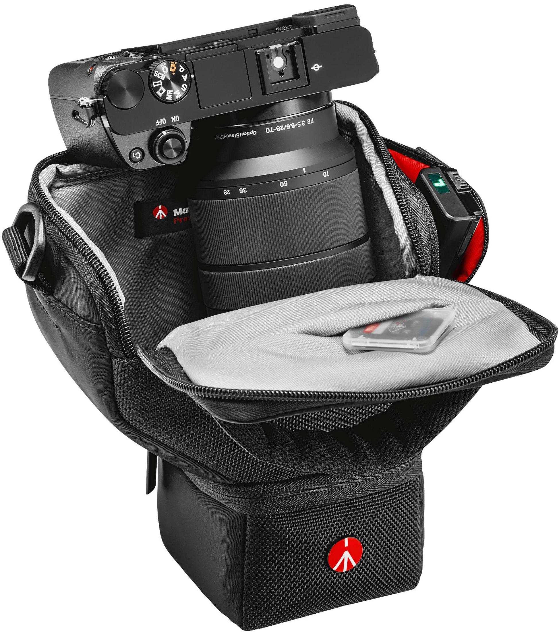 Camera en lens in een zwarte tas. SD-kaart zichtbaar. Open tas op witte achtergrond.