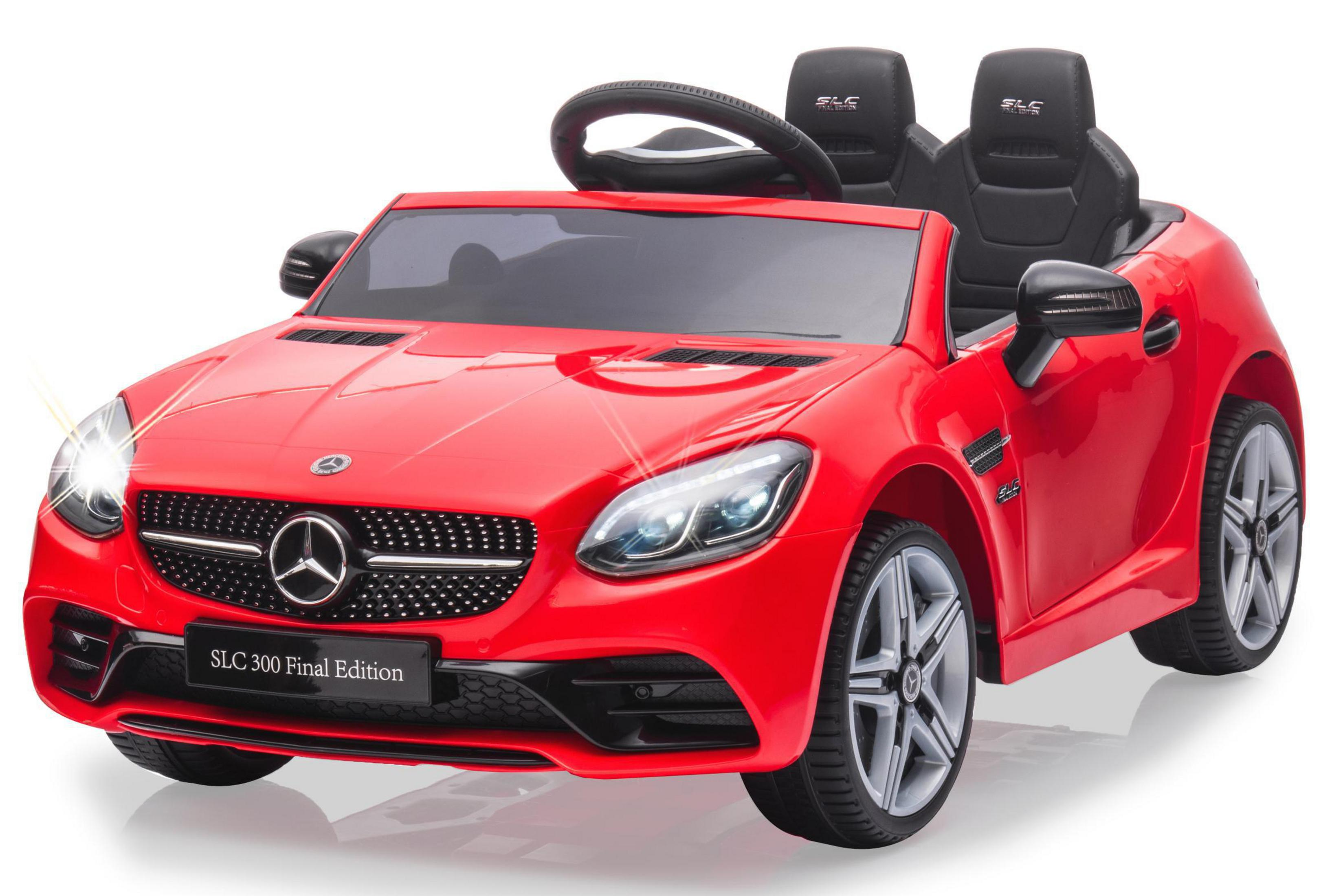 Rotes Spielzeugauto, ein Mercedes SLC 300, mit eingeschaltetem Scheinwerfer.