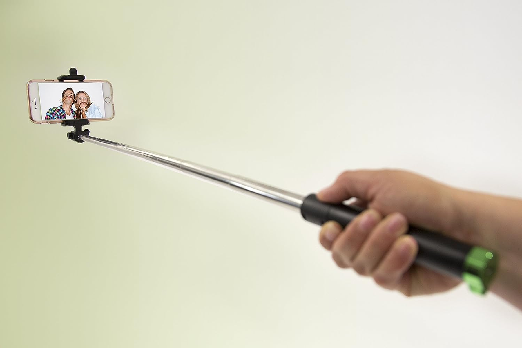 Ein Selfie-Stick mit einem Telefon mit einem Cartoon-Bild von zwei Personen, auf Weiß.