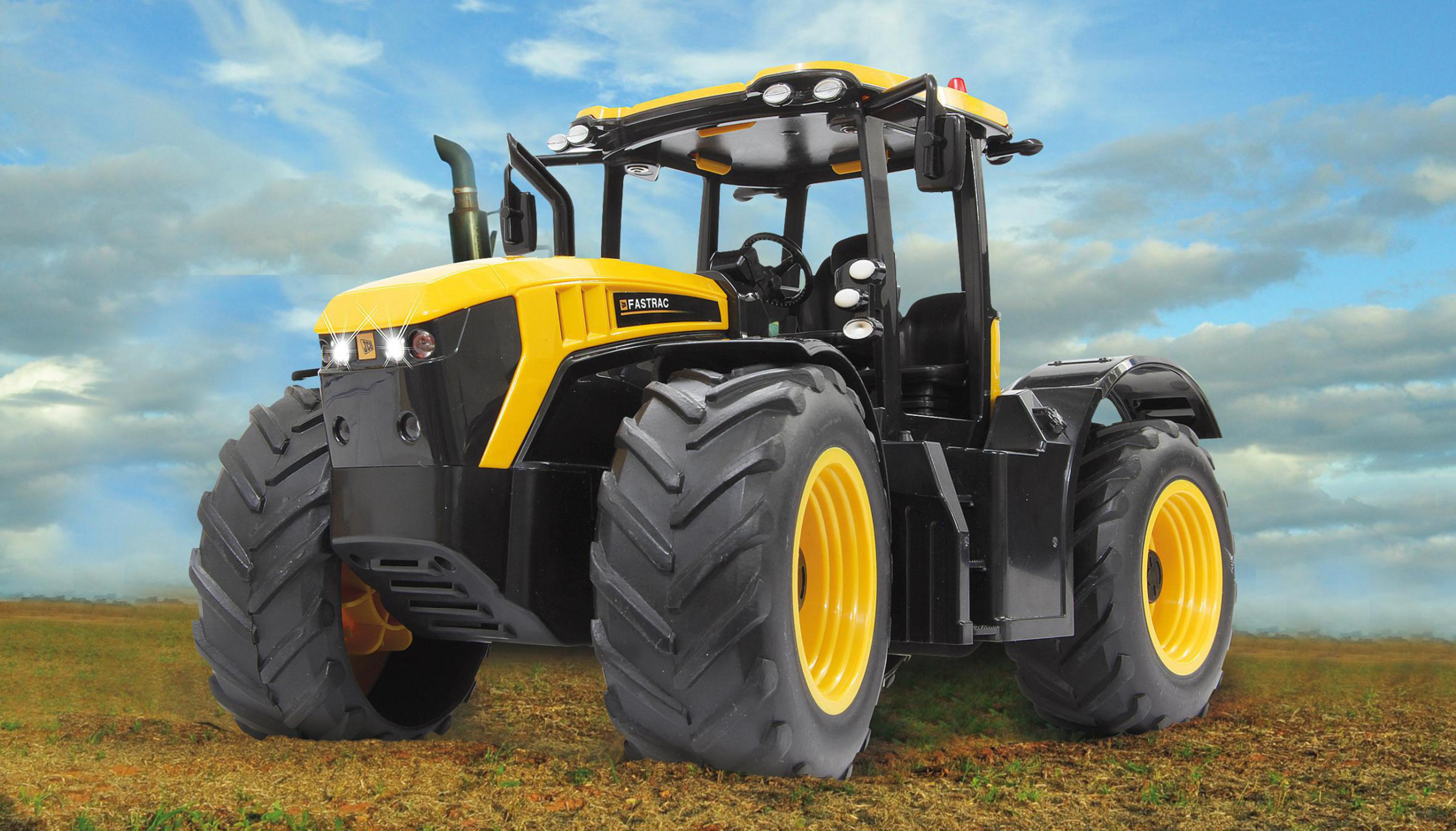 Gelb-schwarzer Traktor auf Feld, mit bewölktem Himmel.