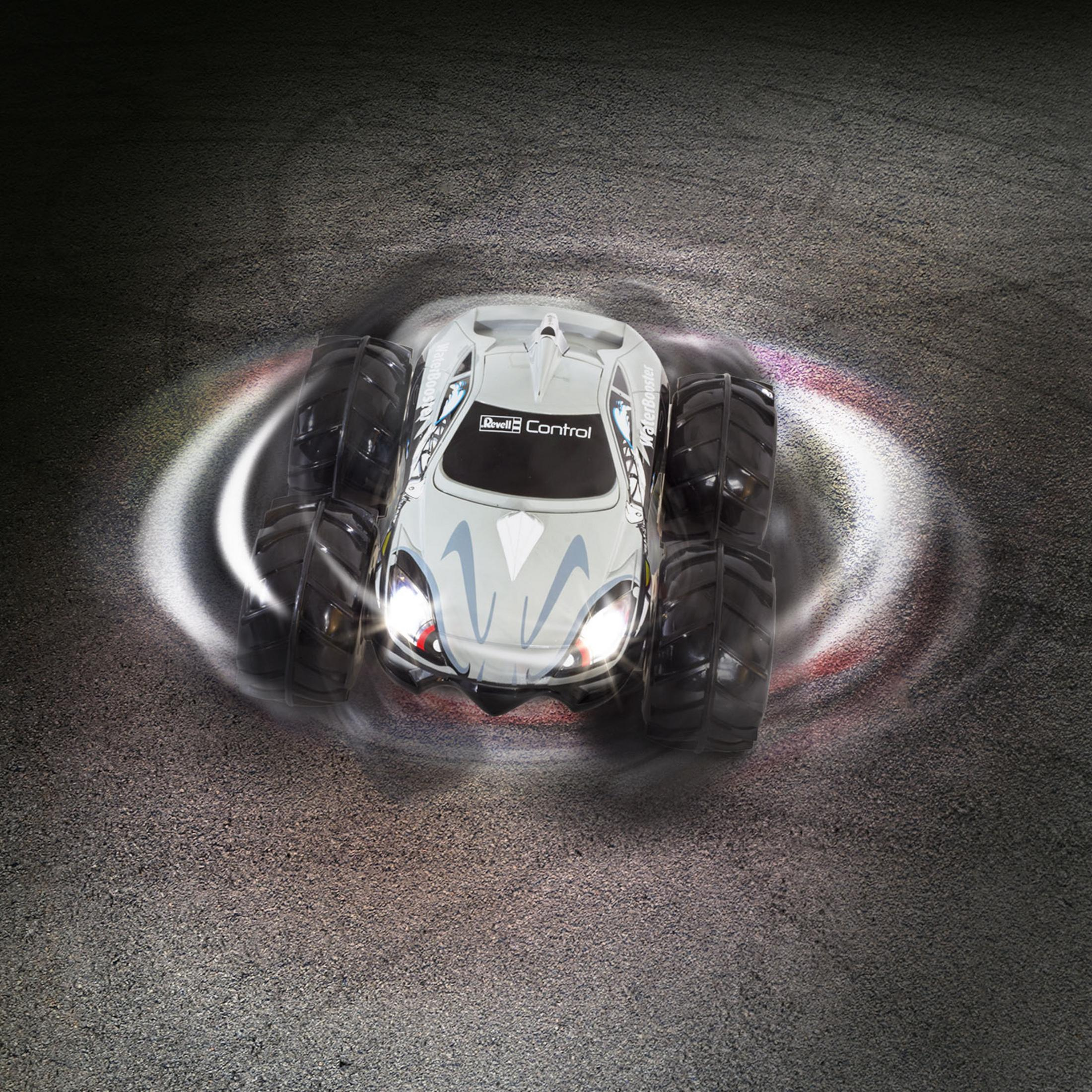 Graues ferngesteuertes Auto mit Spinn-Effekt auf Asphalt. Lichter an.