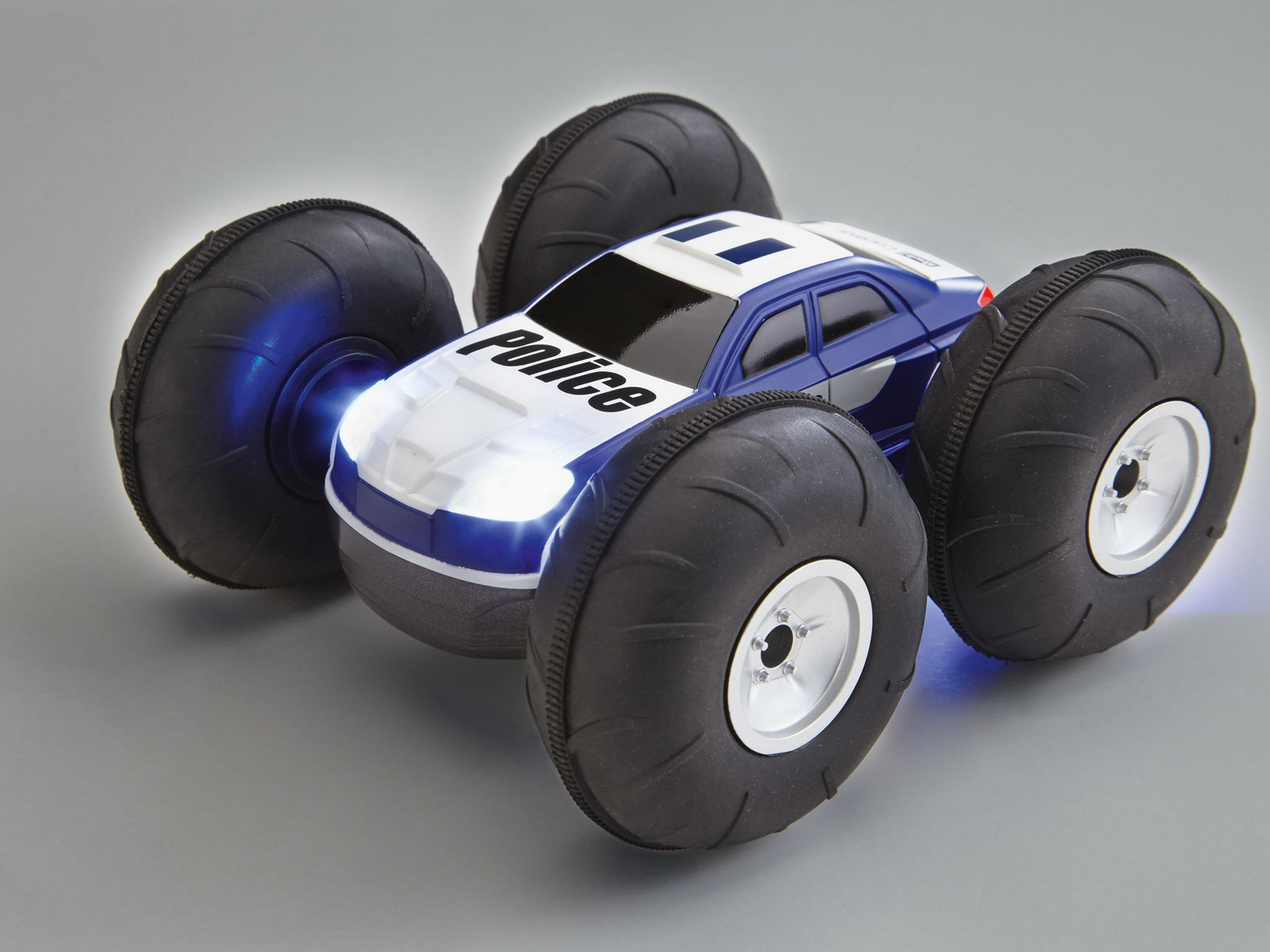 Ein Polizei-Spielzeugauto mit großen Rädern, blau-weißer Farbe und Blinklichtern.